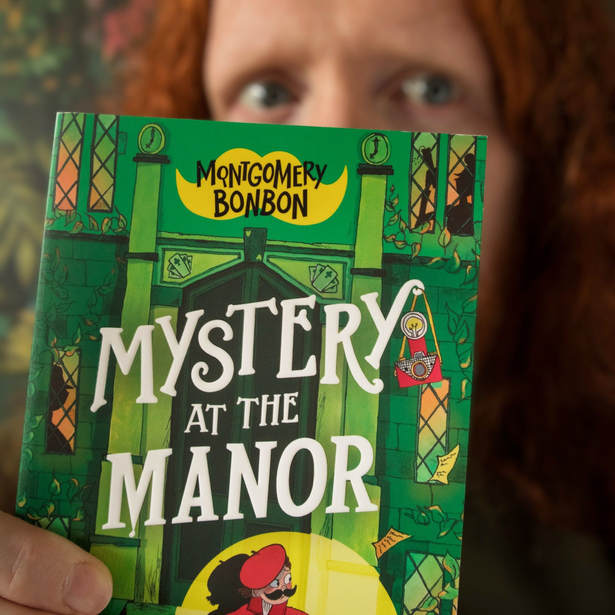 Me, out of focus, behind the green cover of book 3: Mystery at the Manor