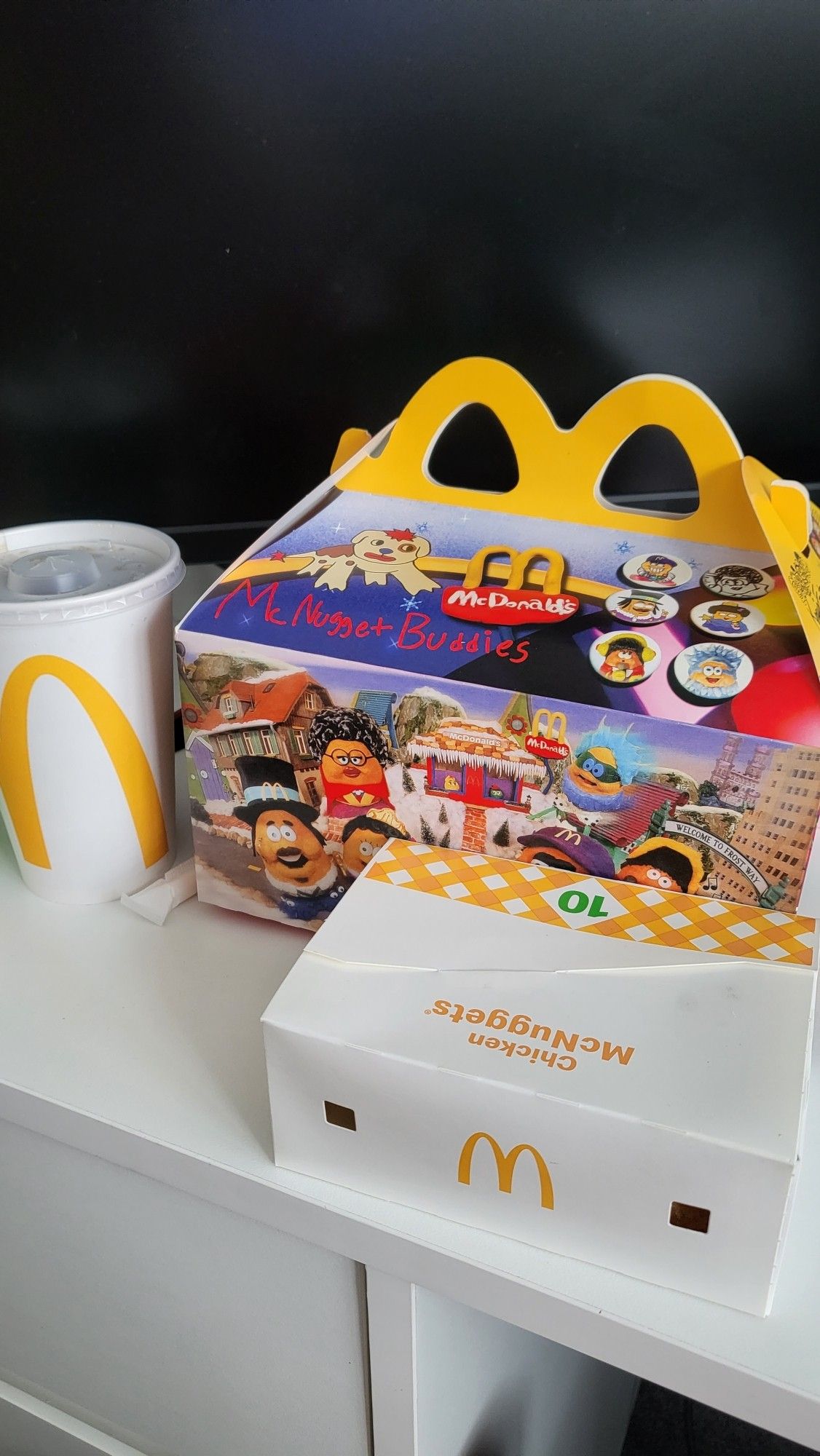 Photo of mcnuggets buddies box next to chicken mcnuggets box and McDonald's drink