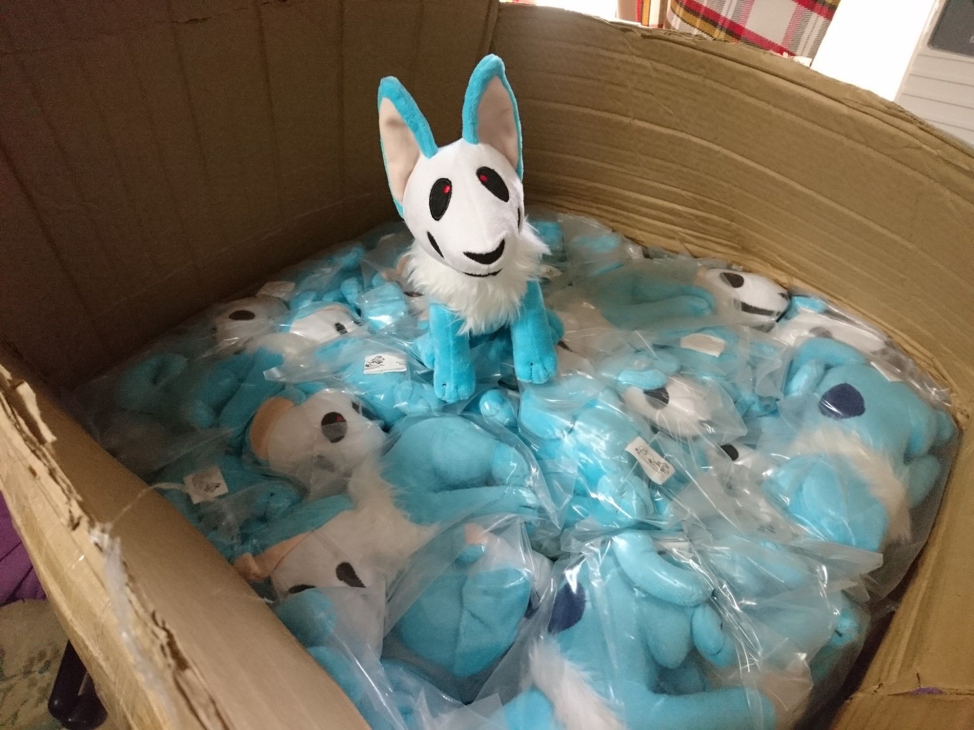 A pile of plush Skulldogs in a large box.