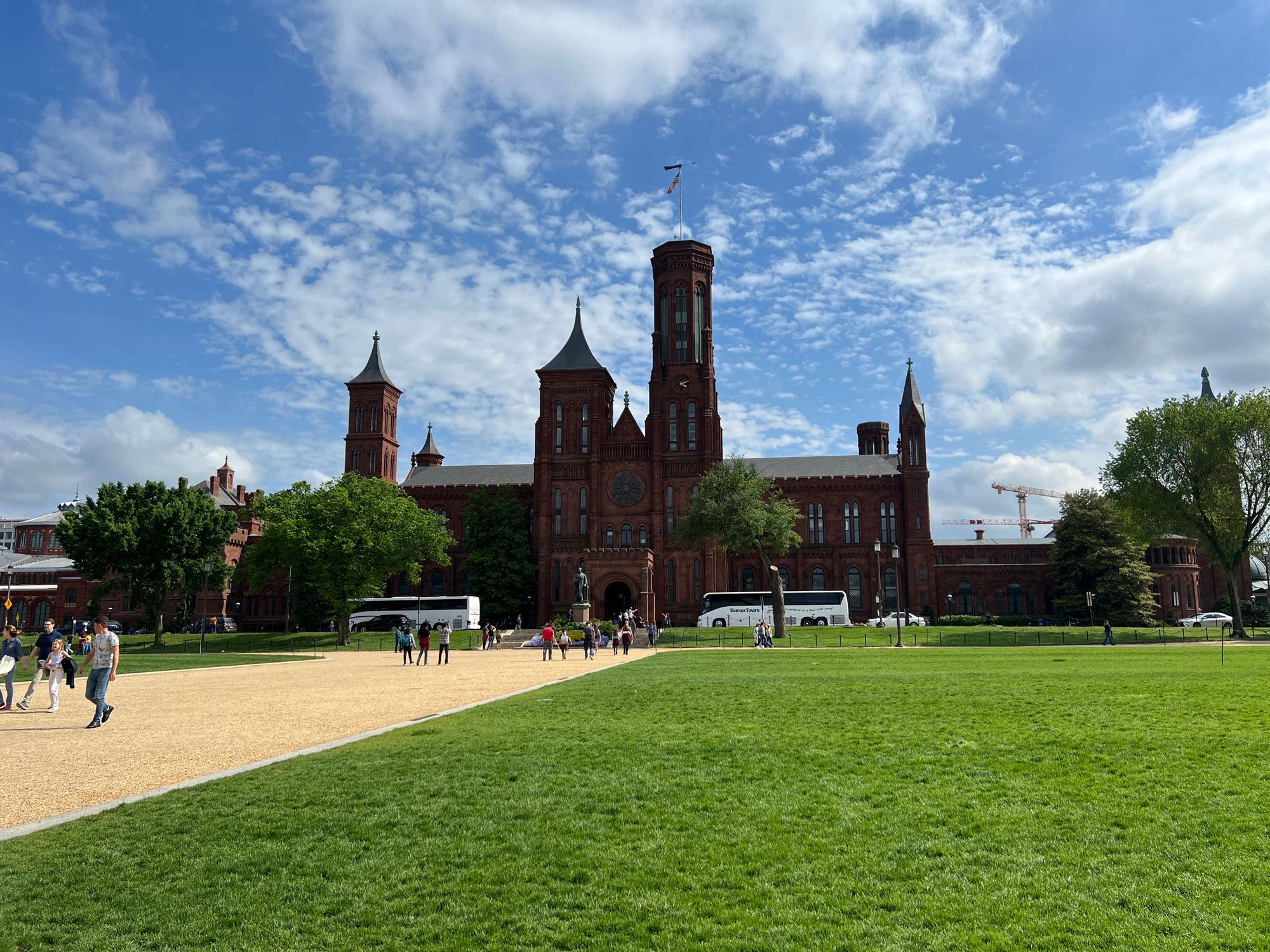 view of the smithsonian castle from the national mall on a partly cloudy day