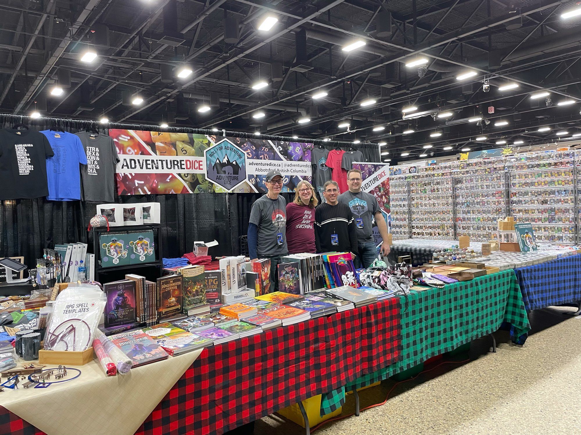 The Adventure Dice booth set up, with four people standing behind smiling.