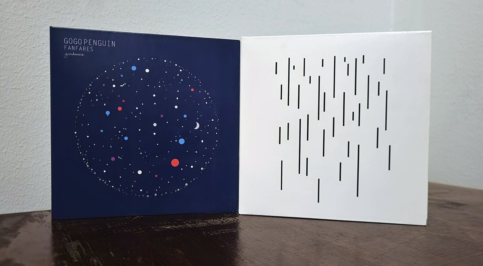 CD releases of GoGo Penguin's first two albums, "Fanfares" and "V2.0 (Deluxe Edition)".