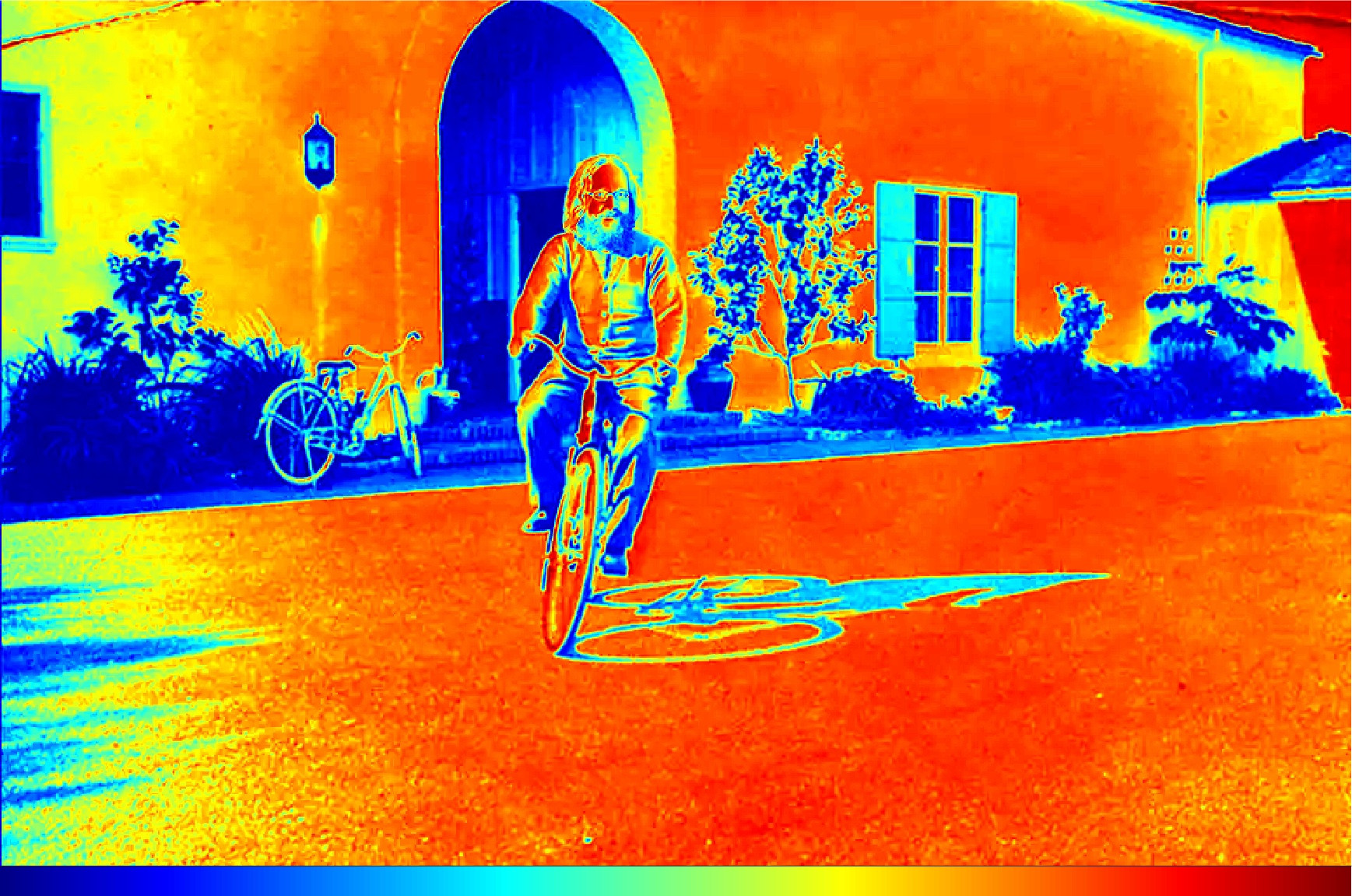 Image of a famous physicist on a bike represented with a visually-distorting rainbow scale.