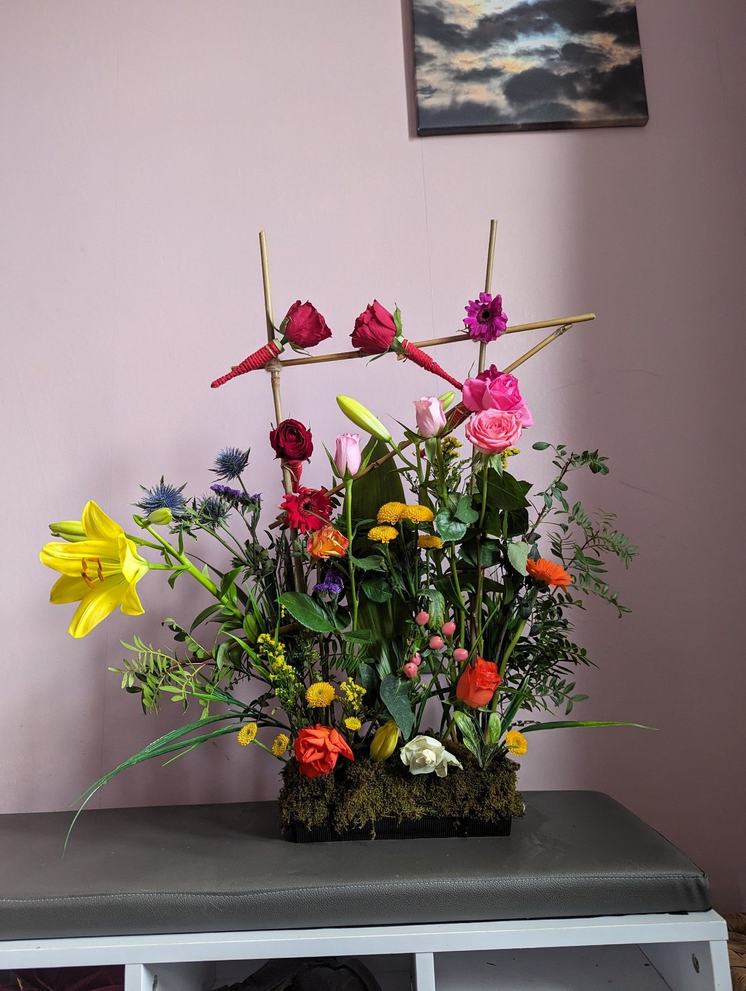 Flower arrangement including roses and gerberas.