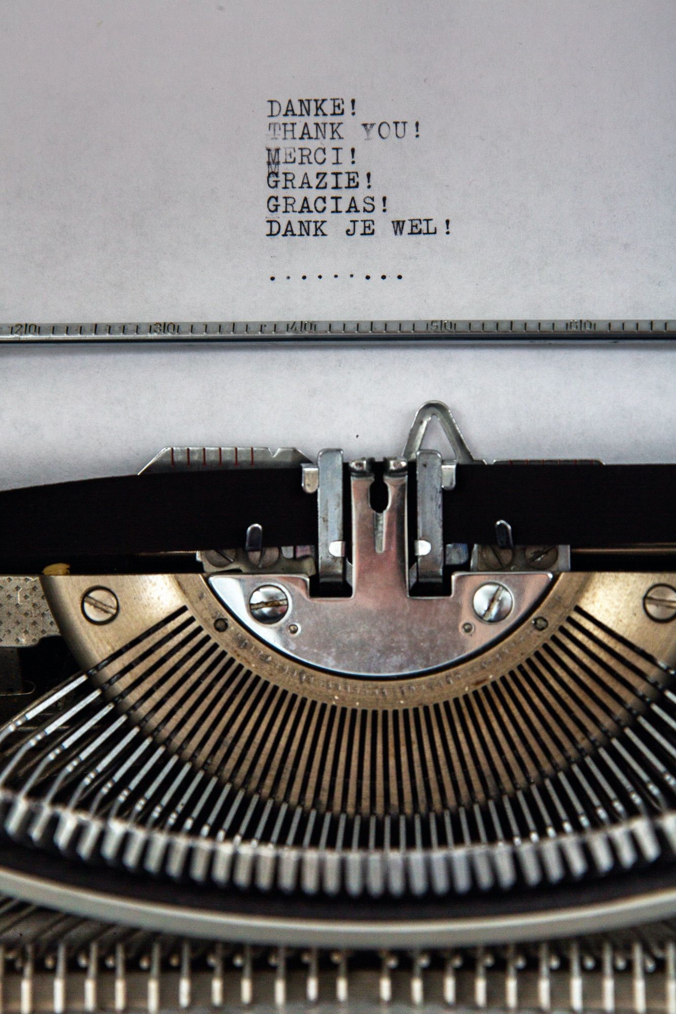 manual typewriter with thank you written in multiple languages on a piece of white typewriter paper