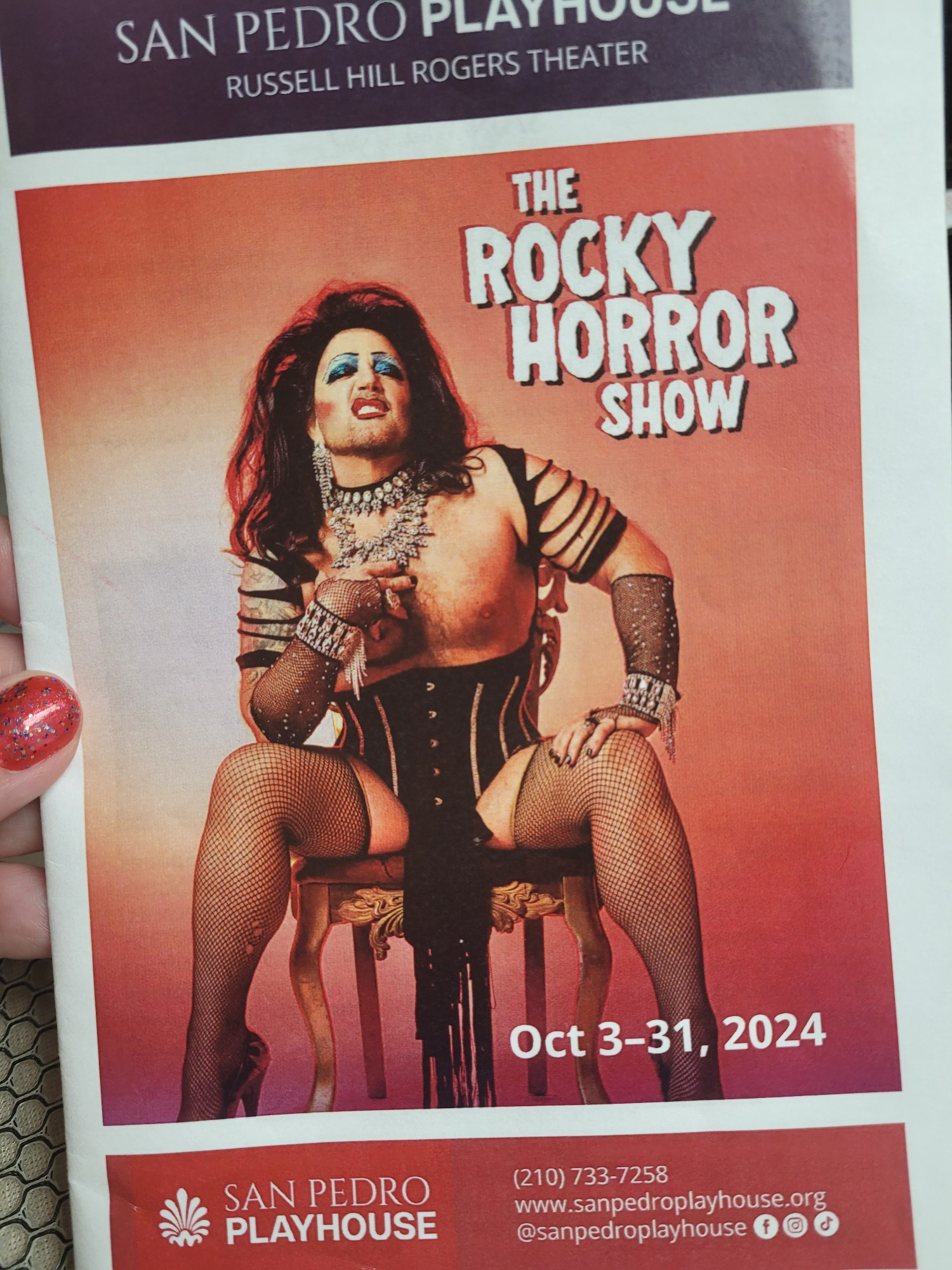 Cover of a program book for The Rocky Horror Show starring Lee Marshall. Lee is a buff man wearing women's underwear, makeup and heels, and looks both frightening and hot.