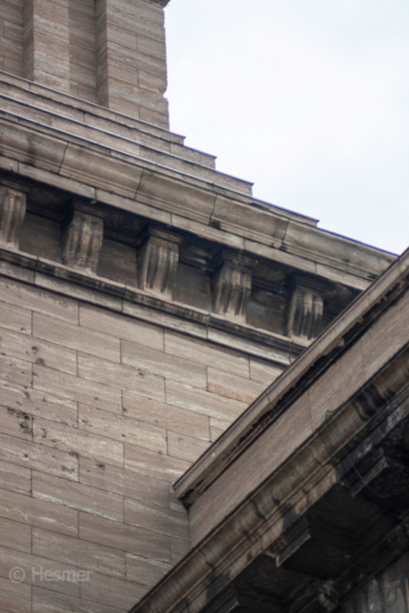 Detail am Pergamon-Musum. Dachelemente und Brüstungen bilden verschiedene Diagonalen im Bild. Darüber ausgerissener Himmel mit chromatischen Aberrationen, also Farbrändern an den hellen Kanten.