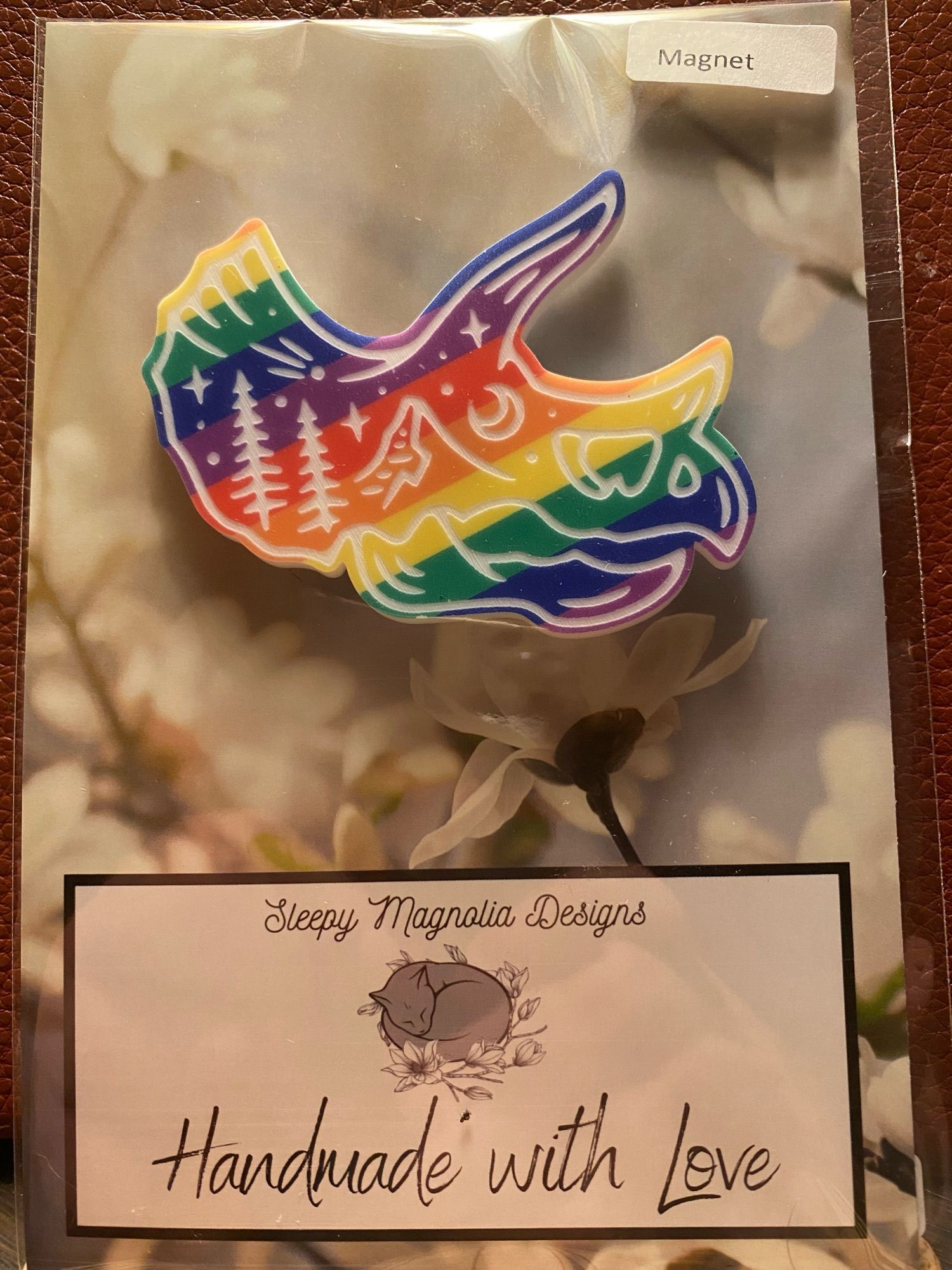 triceratops skull magnet that has rainbows. made my sleepy magnolia designs