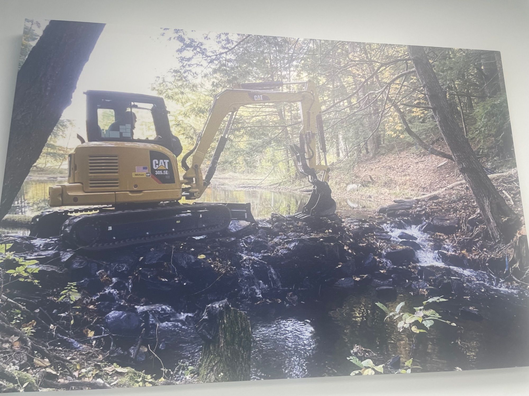 An excavator removing an obstruction from a waterway.