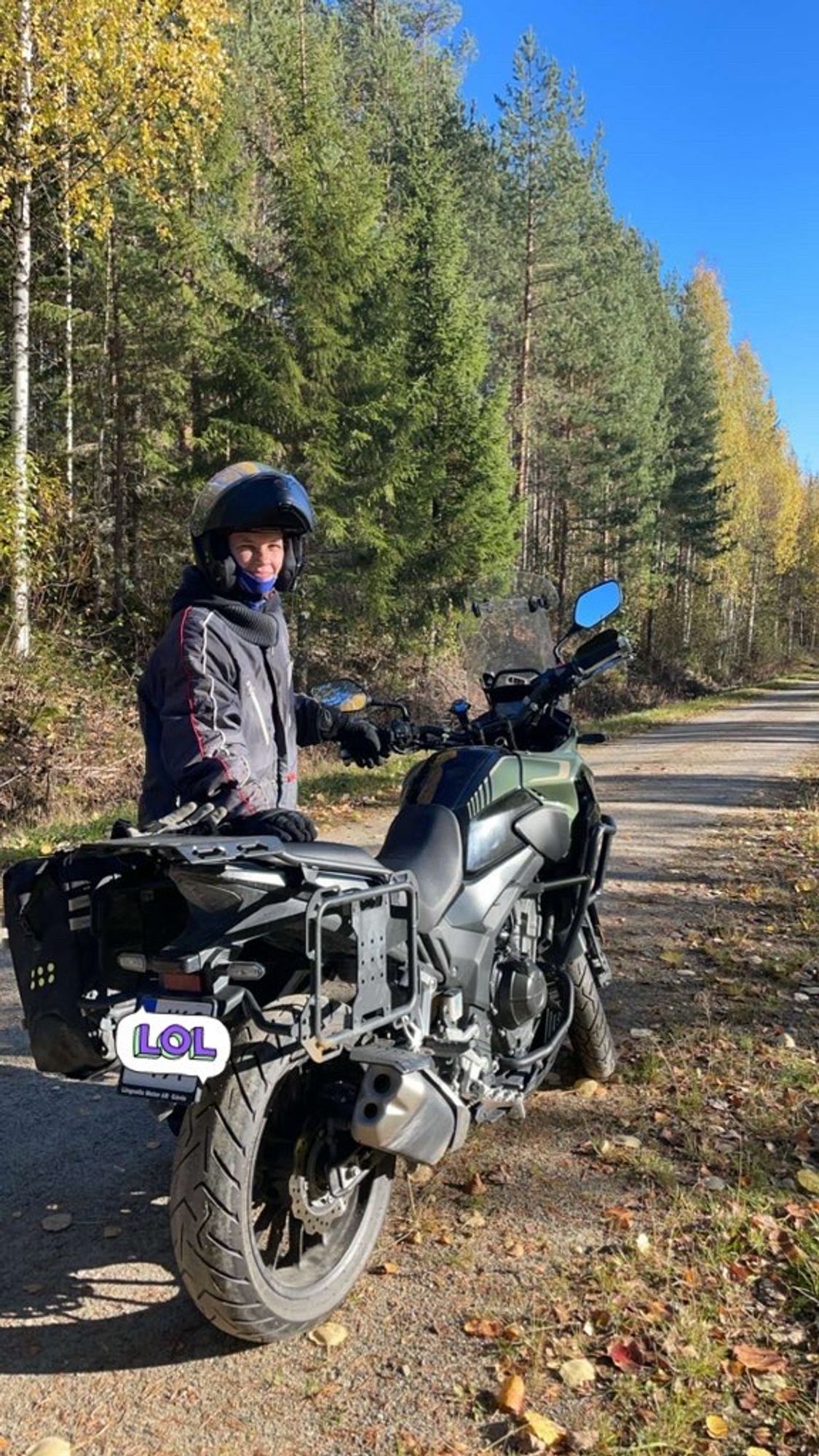 jag iklädd skoteroverall, handskar och mc-hjälm står bredvid en motorcykel