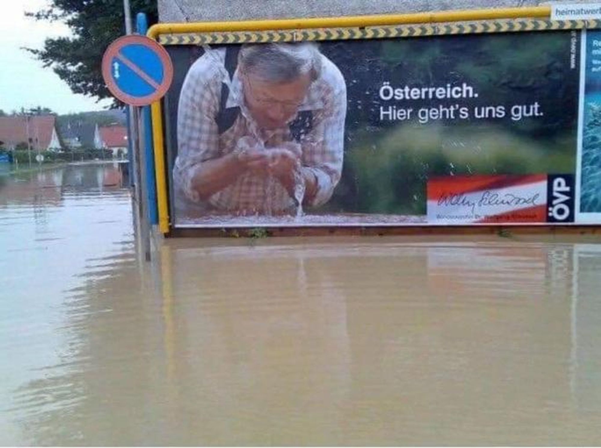 Foto eines alten Wahlplakats der ÖVP: Wolfgang Schüssel (mit Wanderrucksack) beugt sich vor und trinkt gerade Wasser aus seinen Händen, unter dem Plakat und rundherum ist dreckiges Hochwasser, es sieht aus, als würde er direkt daraus trinken.