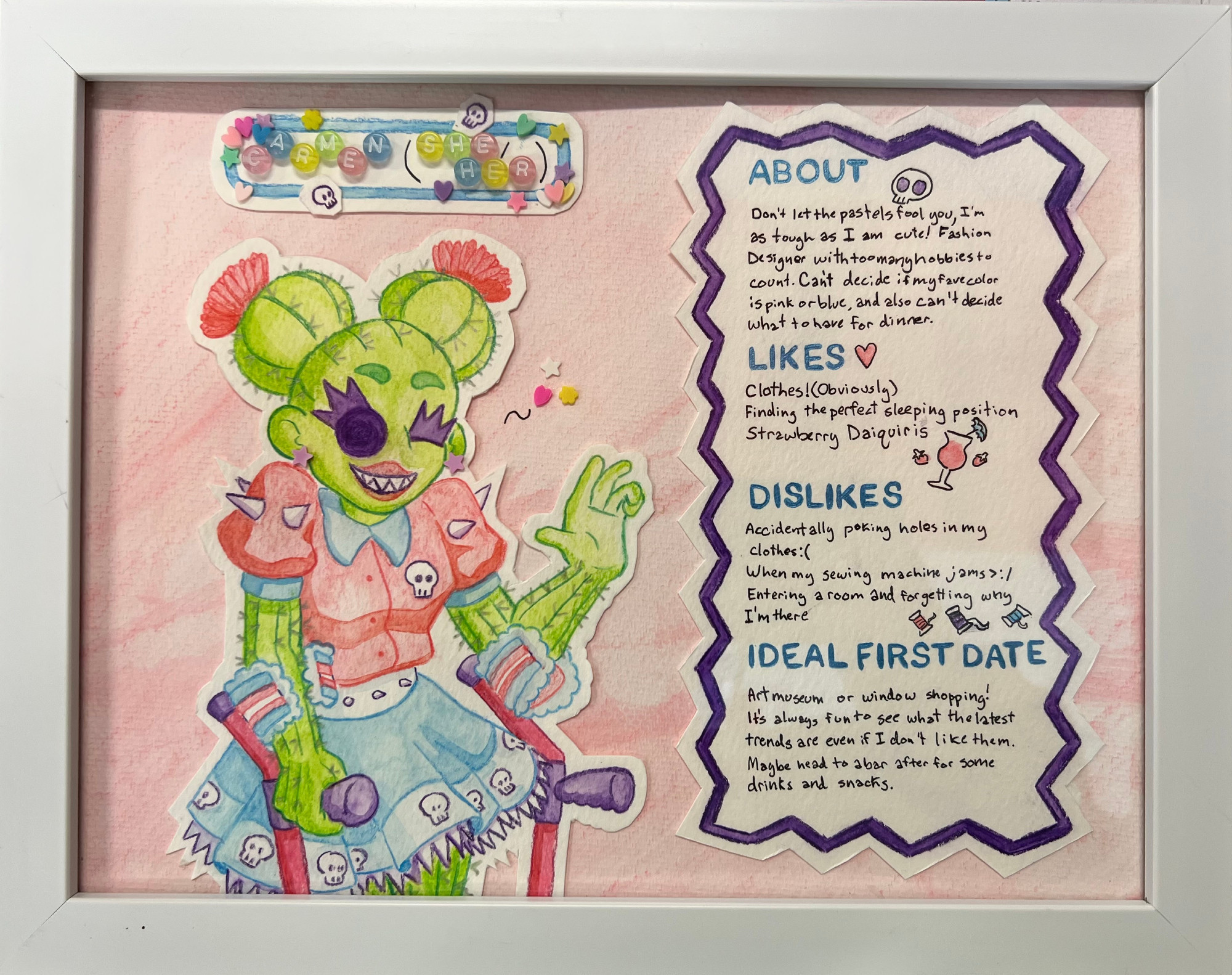 A framed watercolor drawing/collage of a cactus girl, Carmen (detailed image description in the next image). She is is drawn in watercolor and colored pencil then cut and pasted onto a pastel pink background. The nameplate at the top has a collage border of hearts and skulls. Carmen and She/Her are spelled out with beads and next to her is a dating profile.

Her dating profile reads: 
About
Don't let the pastels fool you, I'm as tough as I am cute! Fashion designer with too many hobbies to count. Can't decide if my fave color is pink or blue, and also can't decide what to have for dinner. 

Likes
Clothes! (Obviously) 
Finding the perfect sleeping position 
Strawberry daiquiris 

Dislikes: 
Accidentally poking holes in my clothes :( 
When my sewing machine jams >:/ 
Entering a room and forgetting why I'm there 

Ideal first date 
Art museum or window shopping! It's always fun to see what the latest trends are even if I don't like them. Maybe head to a bar after for some drinks and snack