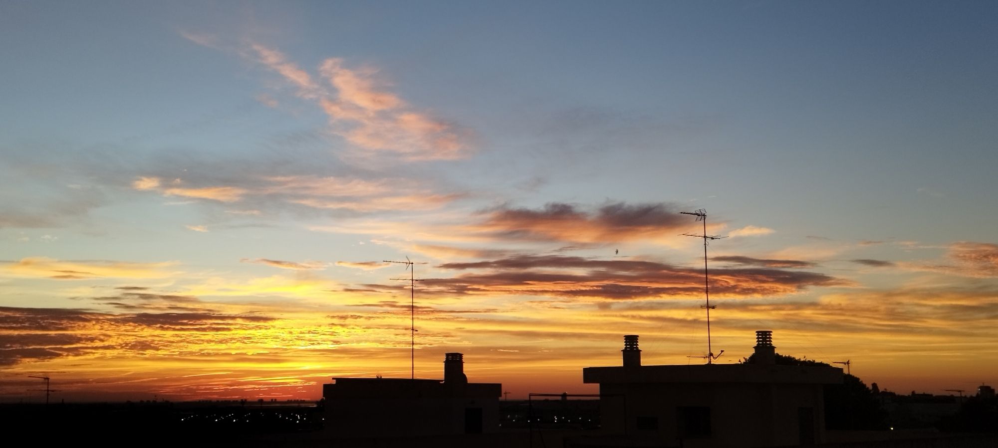 A sunrise picture taken by me, it is (in my opinion) super pretty. Yellow, orange, blue, pinkish and grey painted the sky in the early morning.