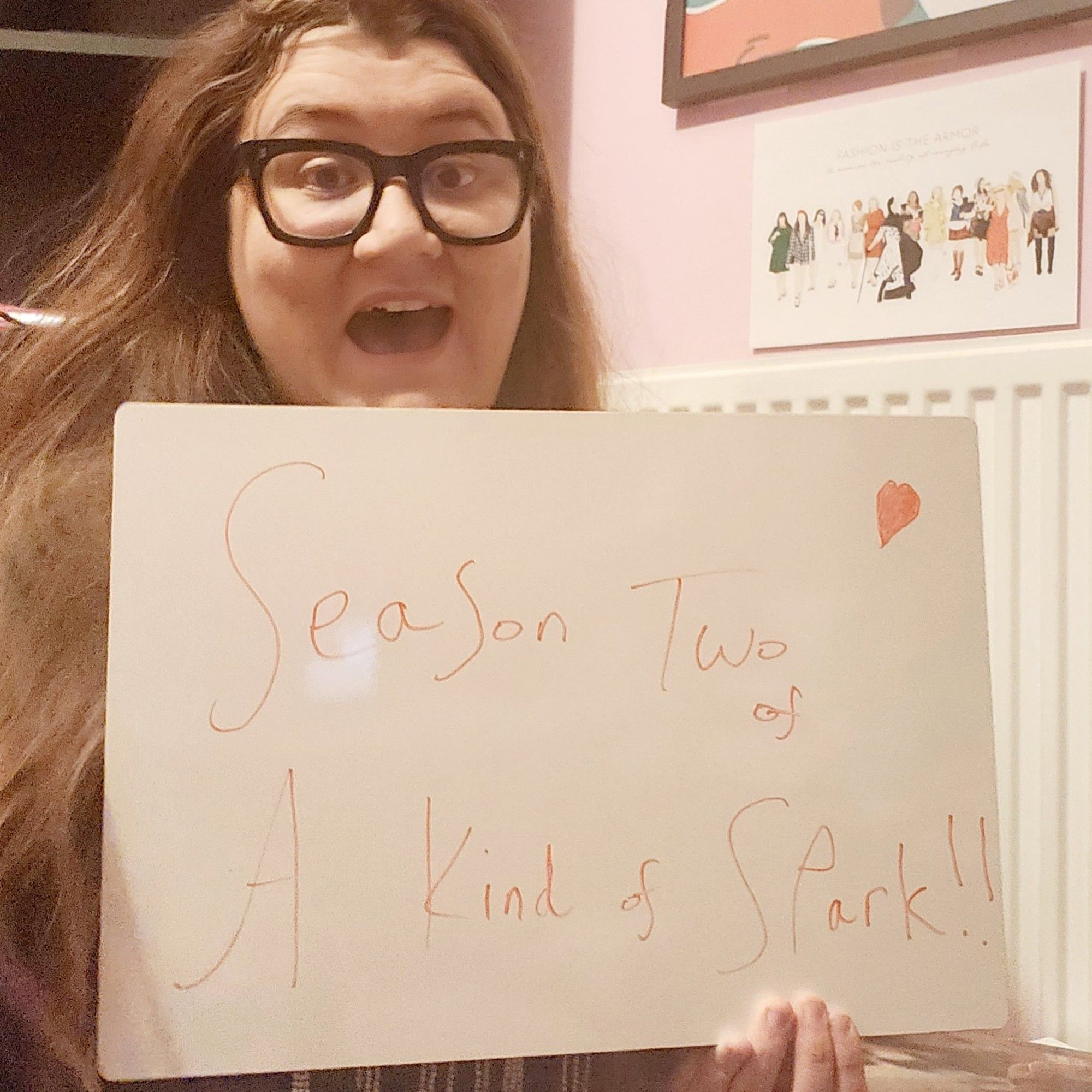 Author holding sign that reads Season Two of A Kind of Spark