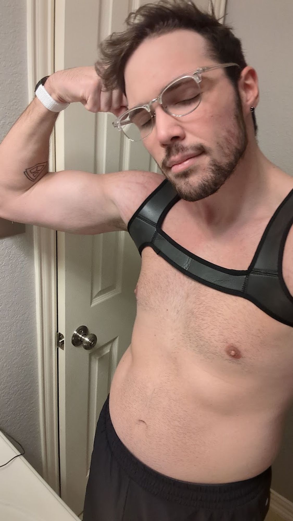 me taking a shirtless selfie in a neoprene chest harness