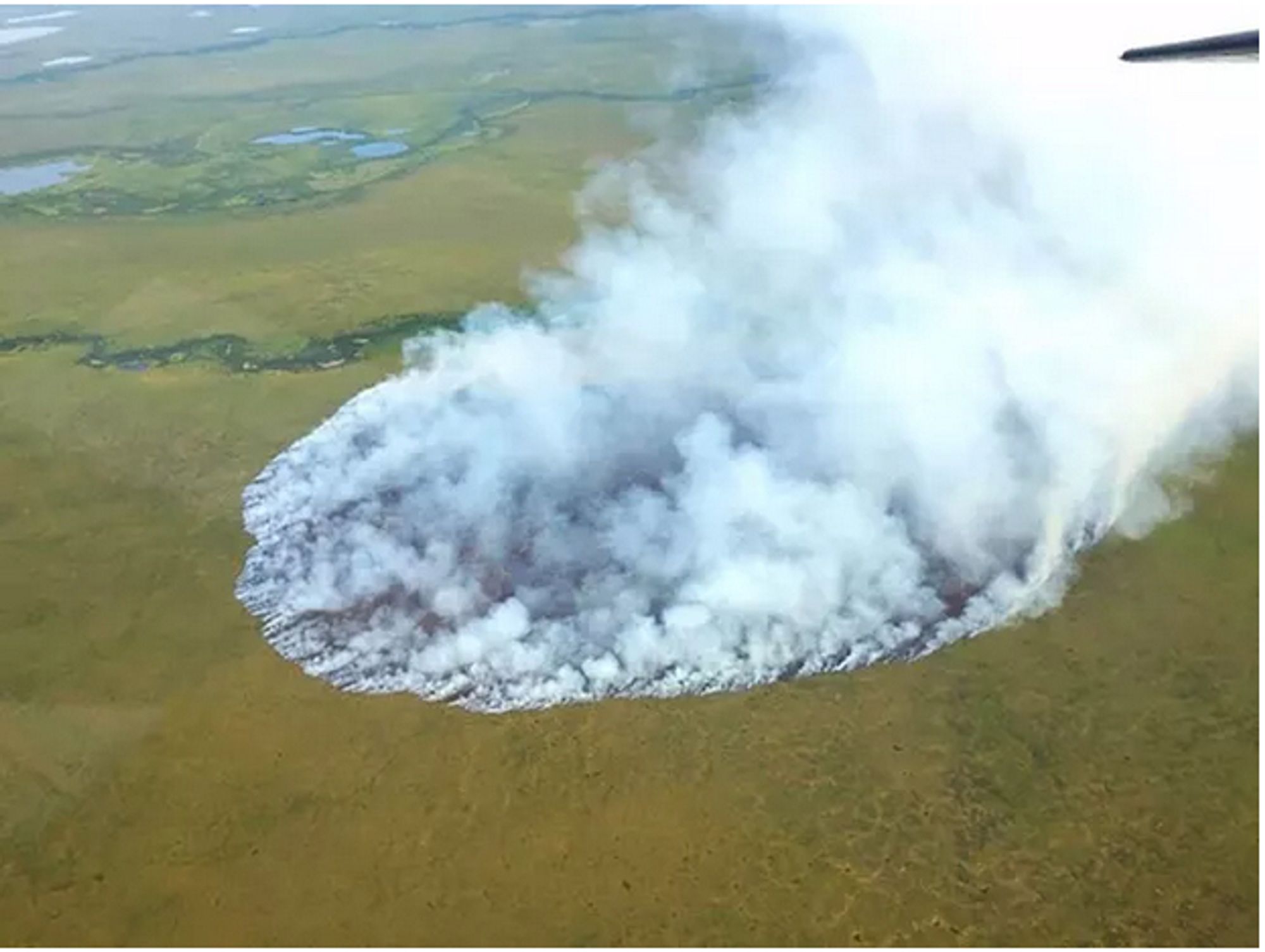 Shows a wildfire in the Arctic tundra