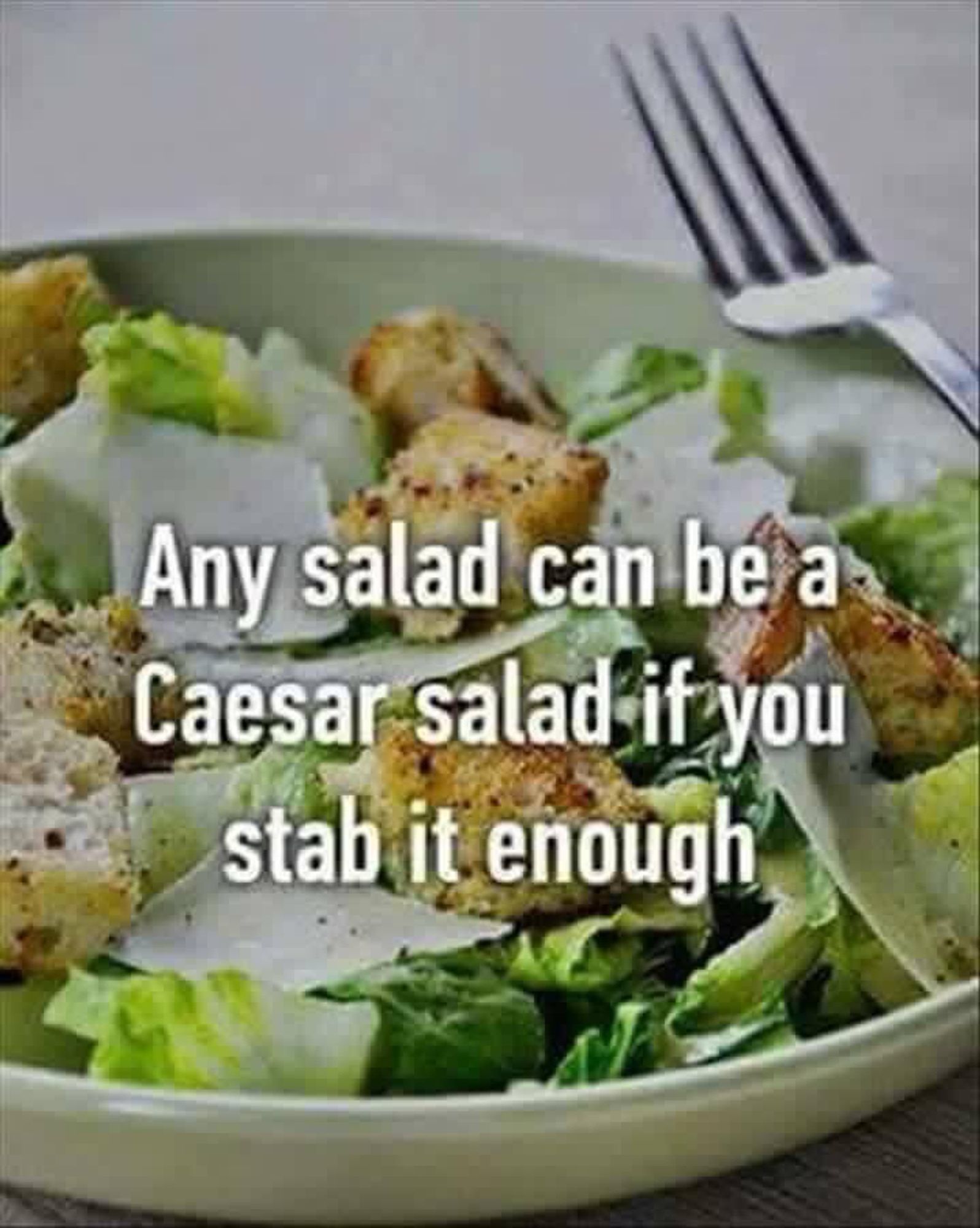 Photo of a basic salad on a plate with a fork. 
“Any salad can be a Caesar salad it you stab it enough”