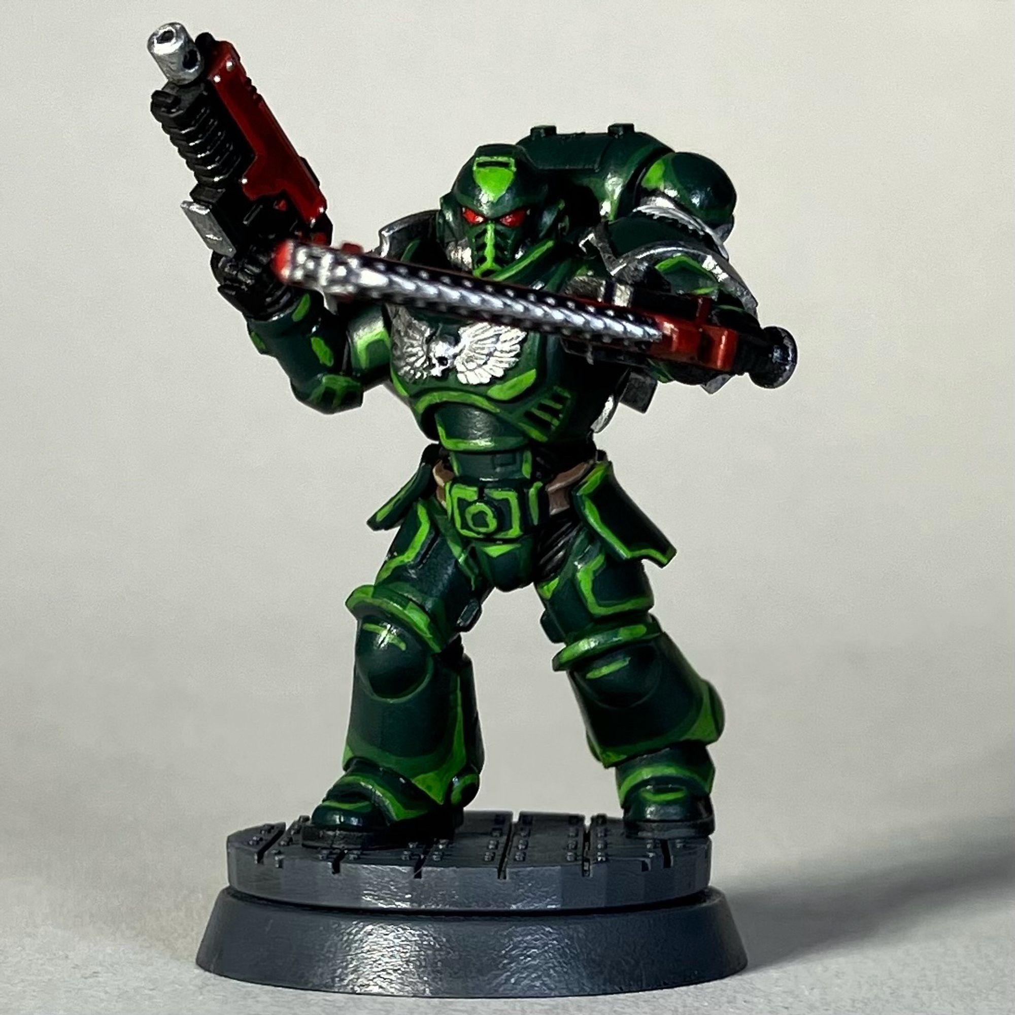 A Warhammer 40k Space Marine, Dark Angels Chapter, in green armor with a red weapon and red chainsword for the game Killteam