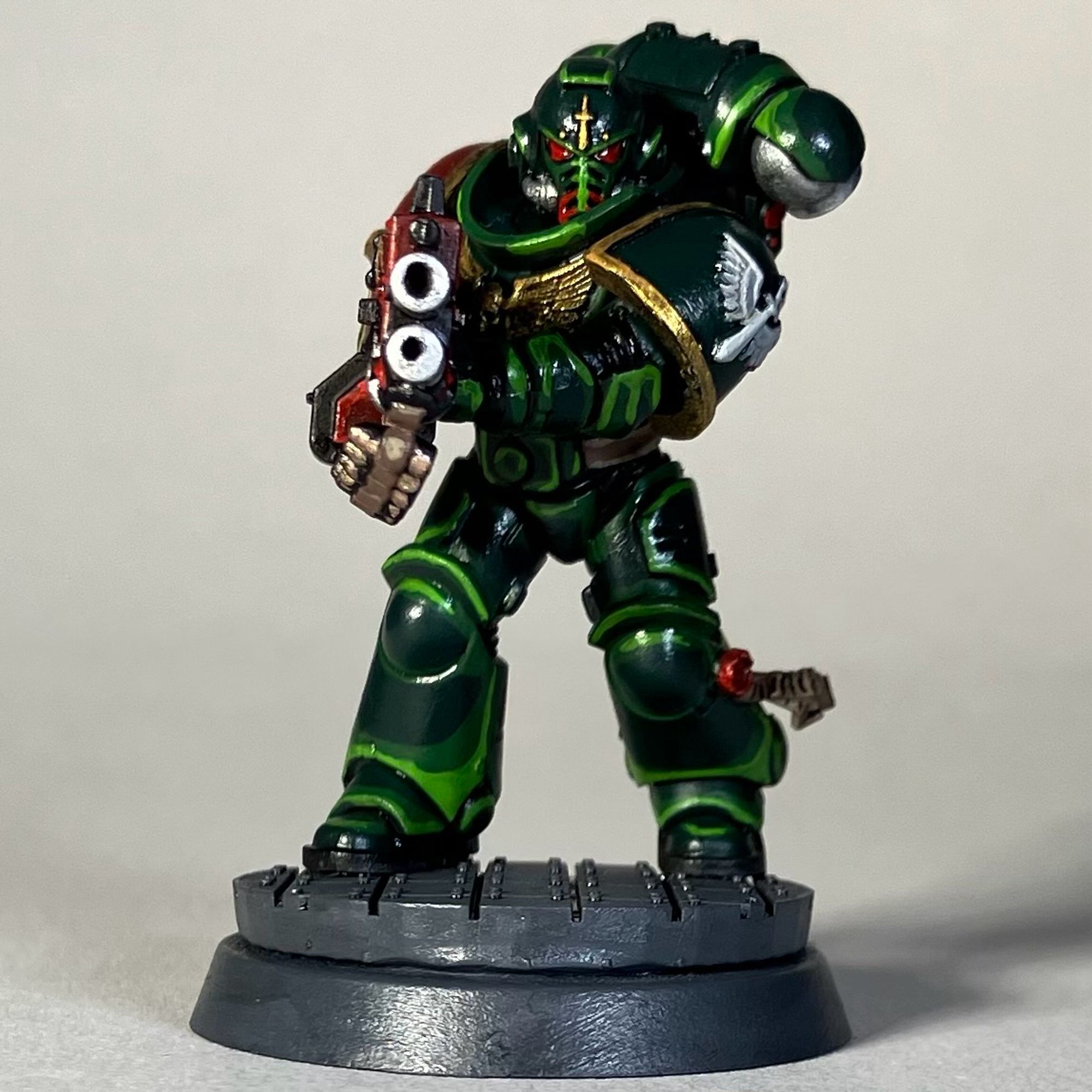 A Warhammer 40k Space Marine, Dark Angels Chapter, in green armor with a red weapon for the game Killteam