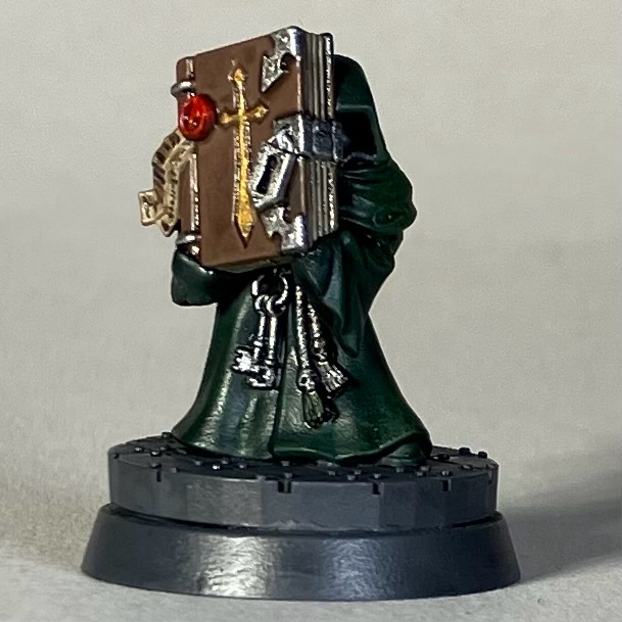 A Warhammer 40k Watcher from Caliban, in a green robe with a large book