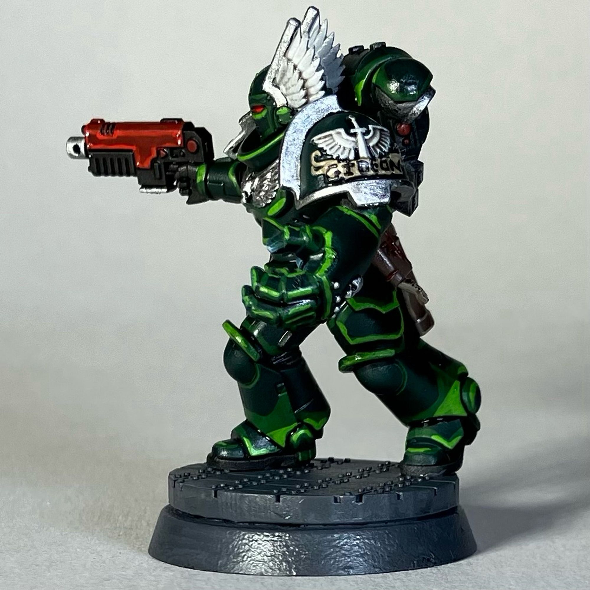 A Warhammer 40k Space Marine, Dark Angels Chapter, in green armor with a red weapon for the game Killteam