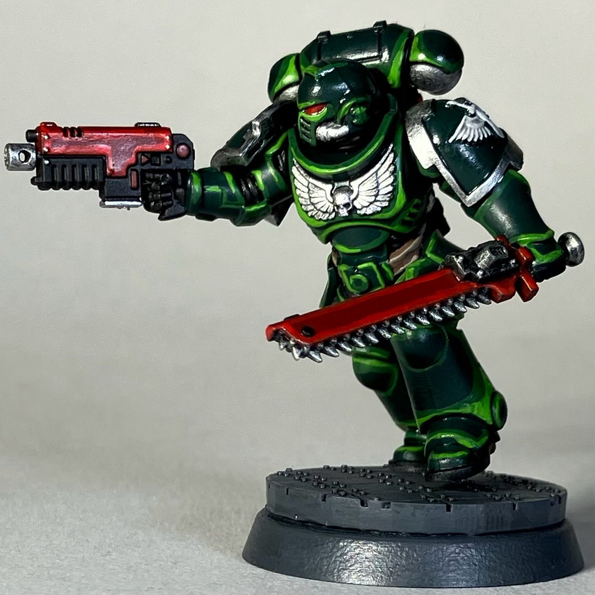 A Warhammer 40k Space Marine, Dark Angels Chapter, in green armor with a red weapon and red chainsword for the game Killteam