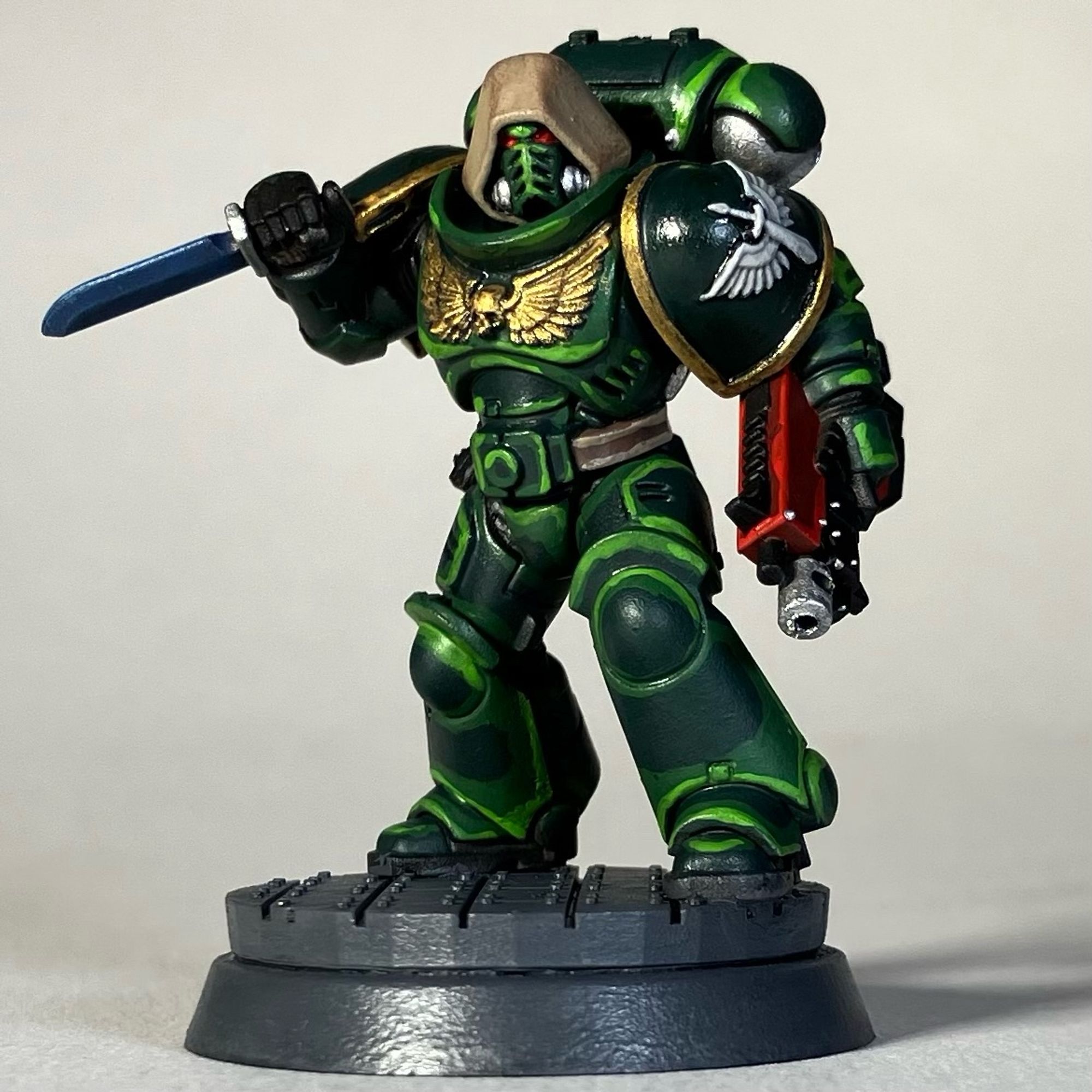 A Warhammer 40k Space Marine, Dark Angels Chapter, in green armor with a red weapon for the game Killteam