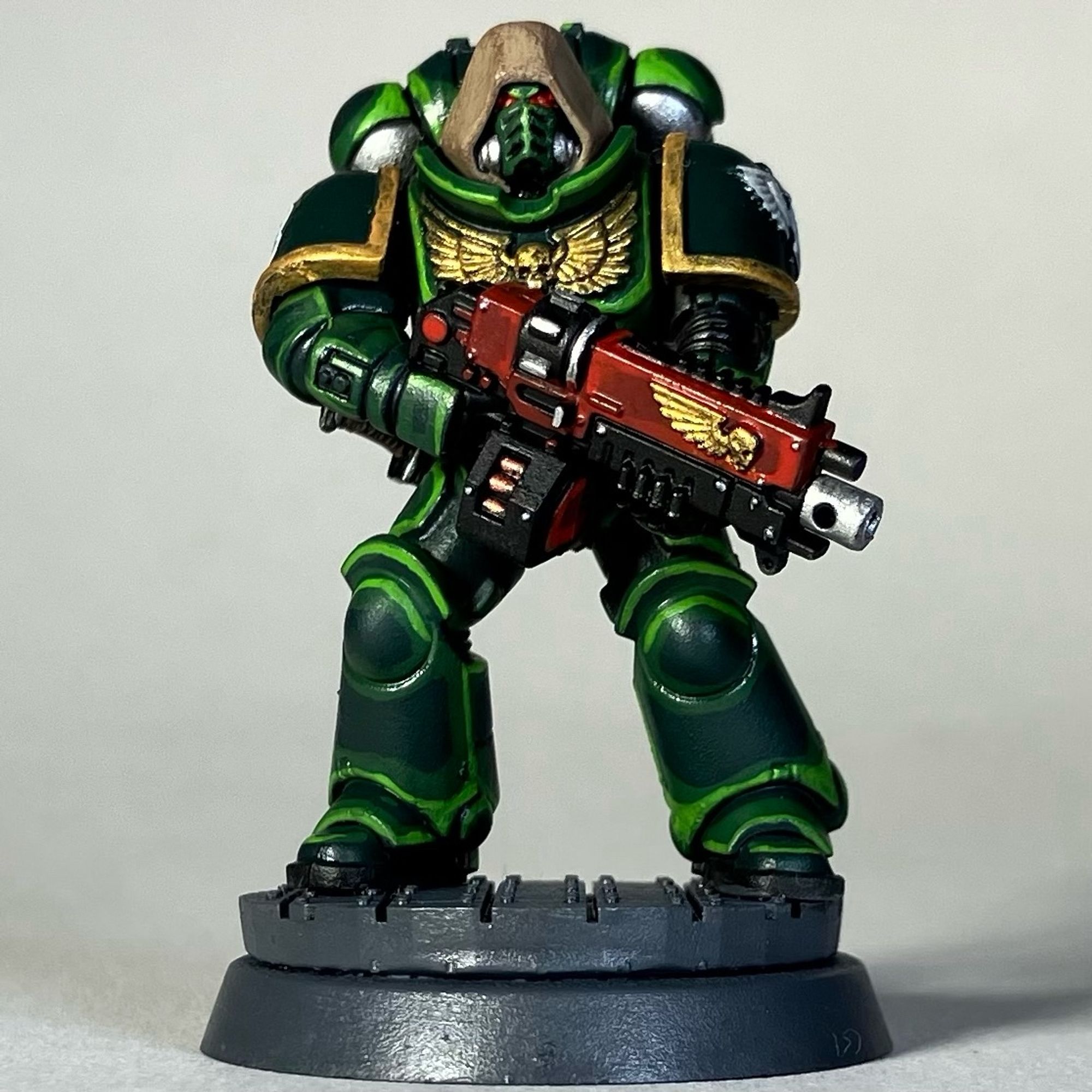 A Warhammer 40k Space Marine, Dark Angels Chapter, in green armor with a red weapon for the game Killteam