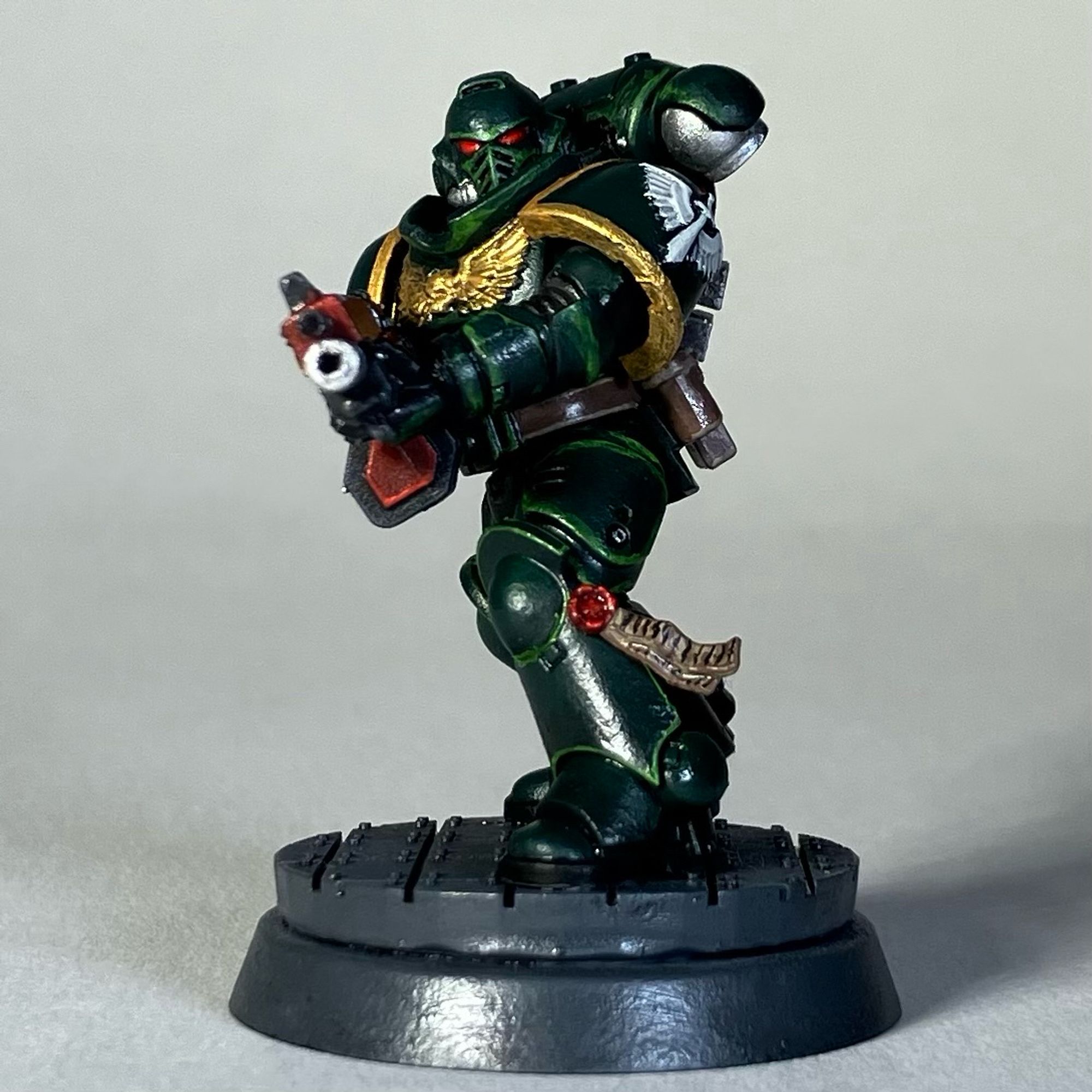 A Warhammer 40k Space Marine, Dark Angels Chapter, in green armor with a red weapon for the game Killteam