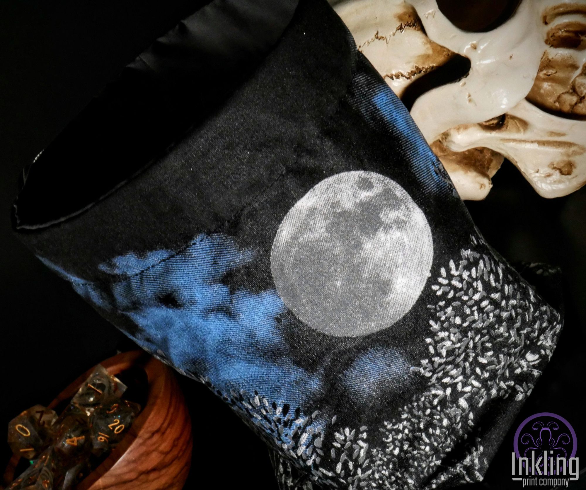 An alternative angle of the bag showing a full moon, cloudy blue night sky, and some shimmering leaves