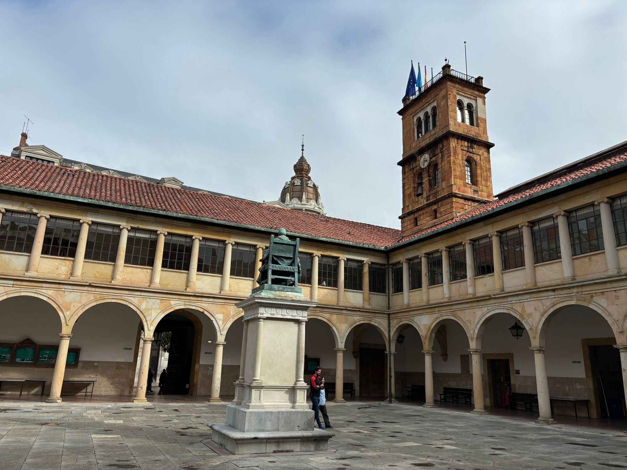 Stone courtyard with statue of seated man in the center (the conference venue)