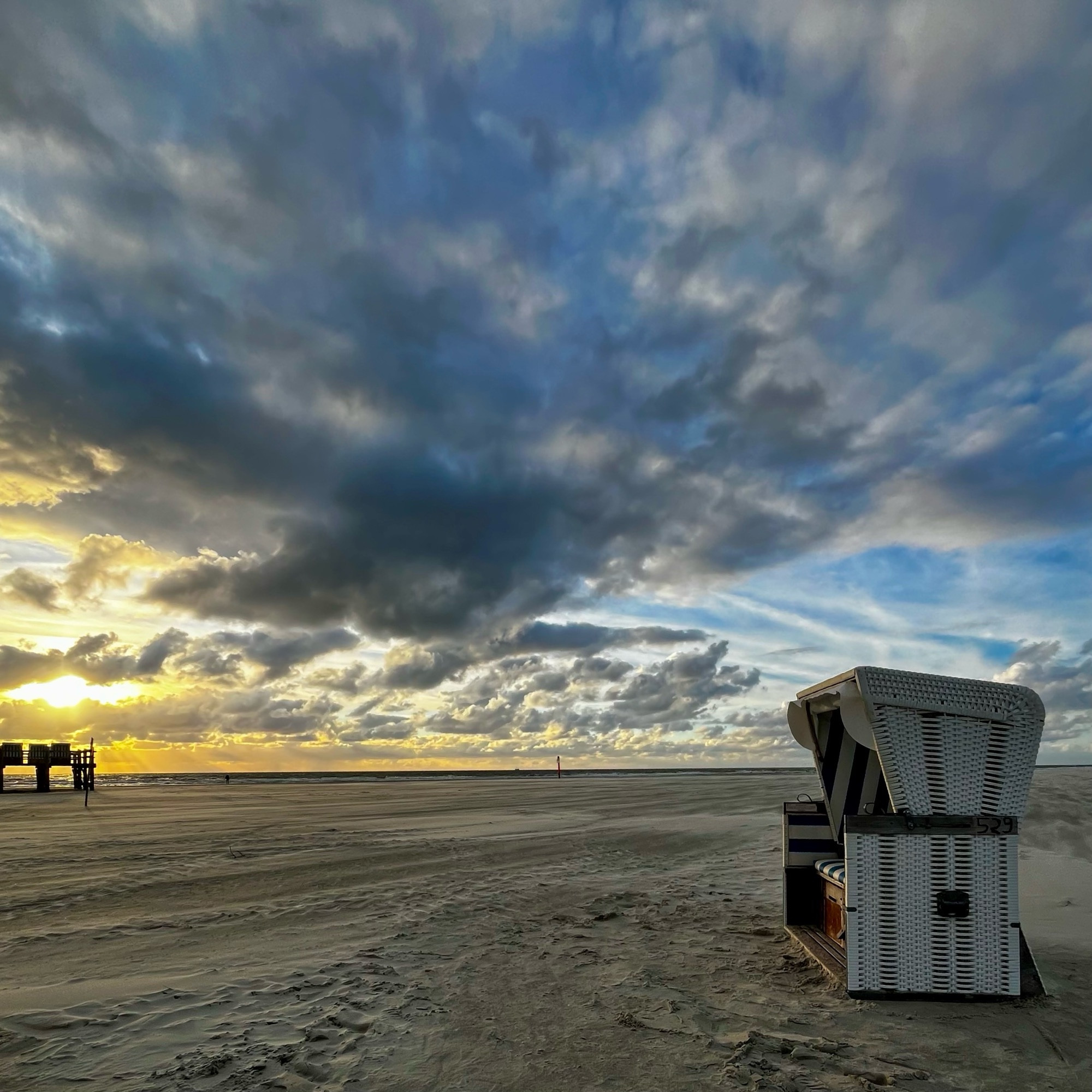 Strandkorb am Meer bei Sonnenuntergang.