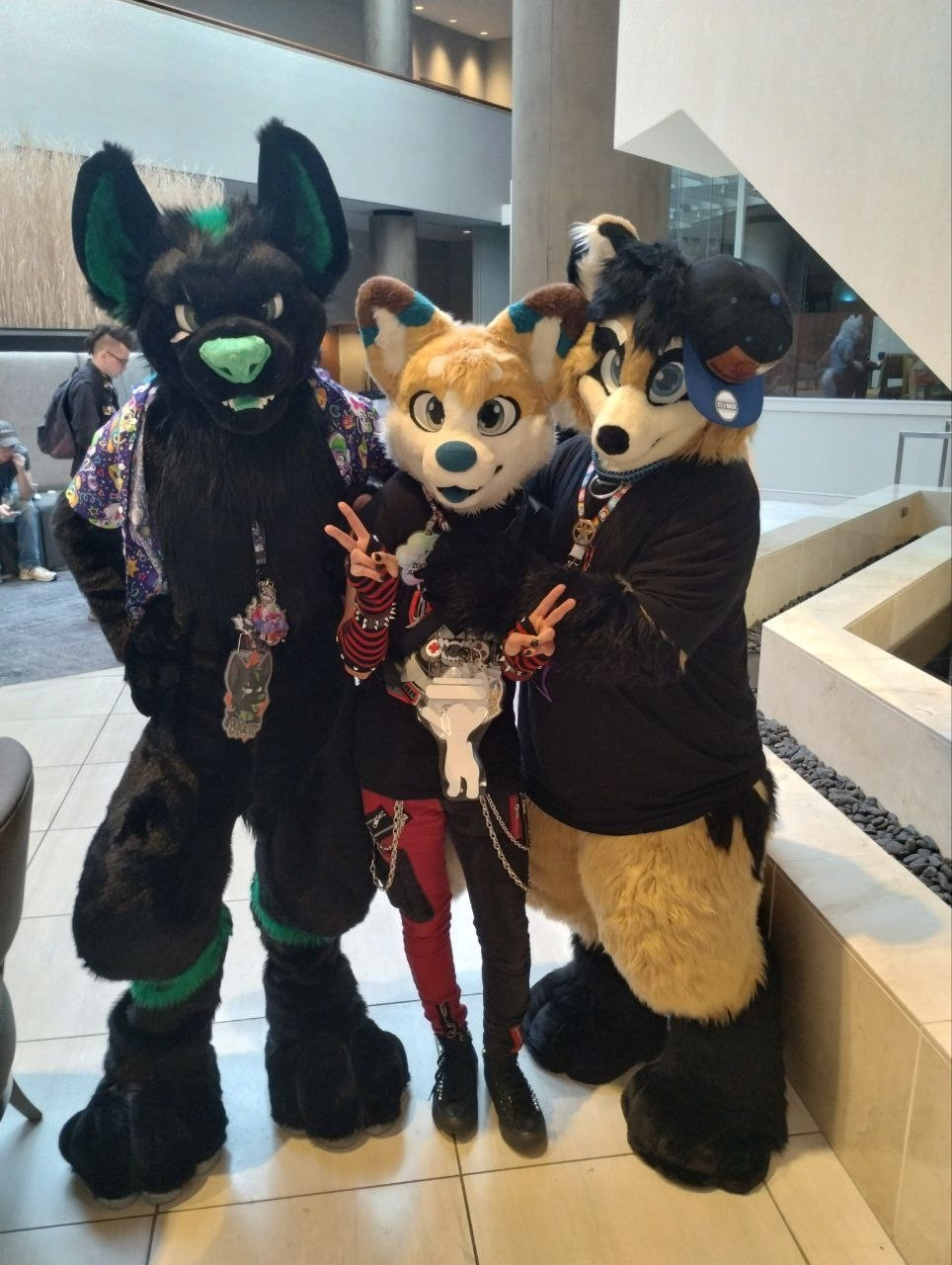 Green and Black Wolf (Skarr De Wolf); Furry Friend Toy Corgie; and Raccoon / Tanuki (Nodnarb Korinzu). Three Furries posing for pics.