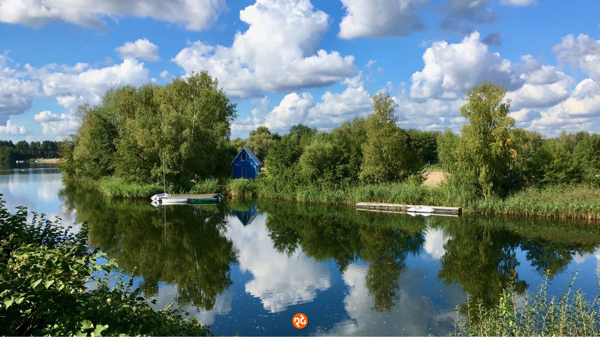 Farbfoto, Querformat: Sommerliches Idyll am Prüßsee bei Güster. Weiße Wolken treiben vor blauem Himmel.