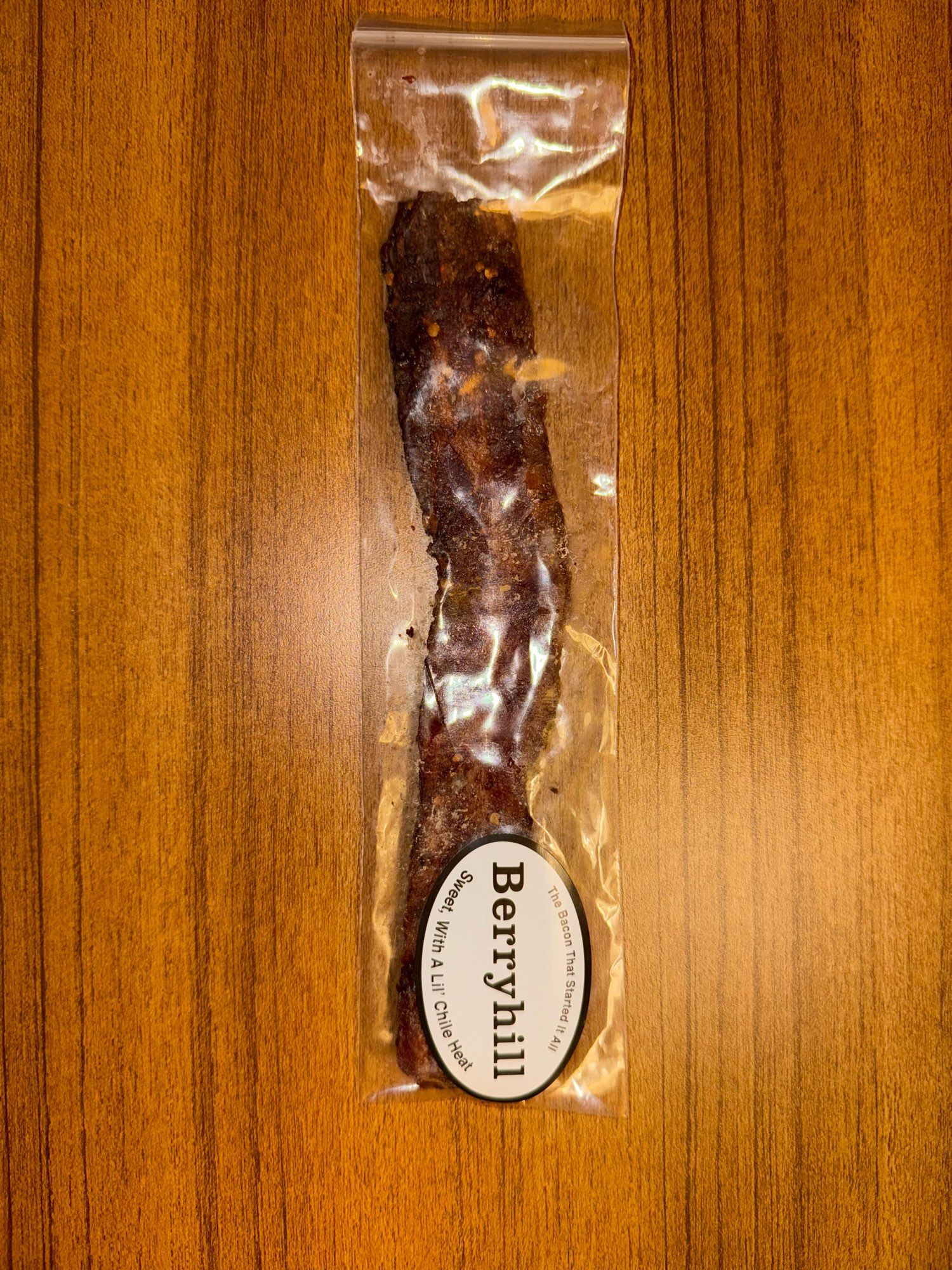 A piece of bacon, in a plastic baggie, says that it’s “the bacon that started it all” and that it’s “sweet, with a lil chile heat”. You find yourself wondering how long bacon lasts at room temperature in a plastic baggie.