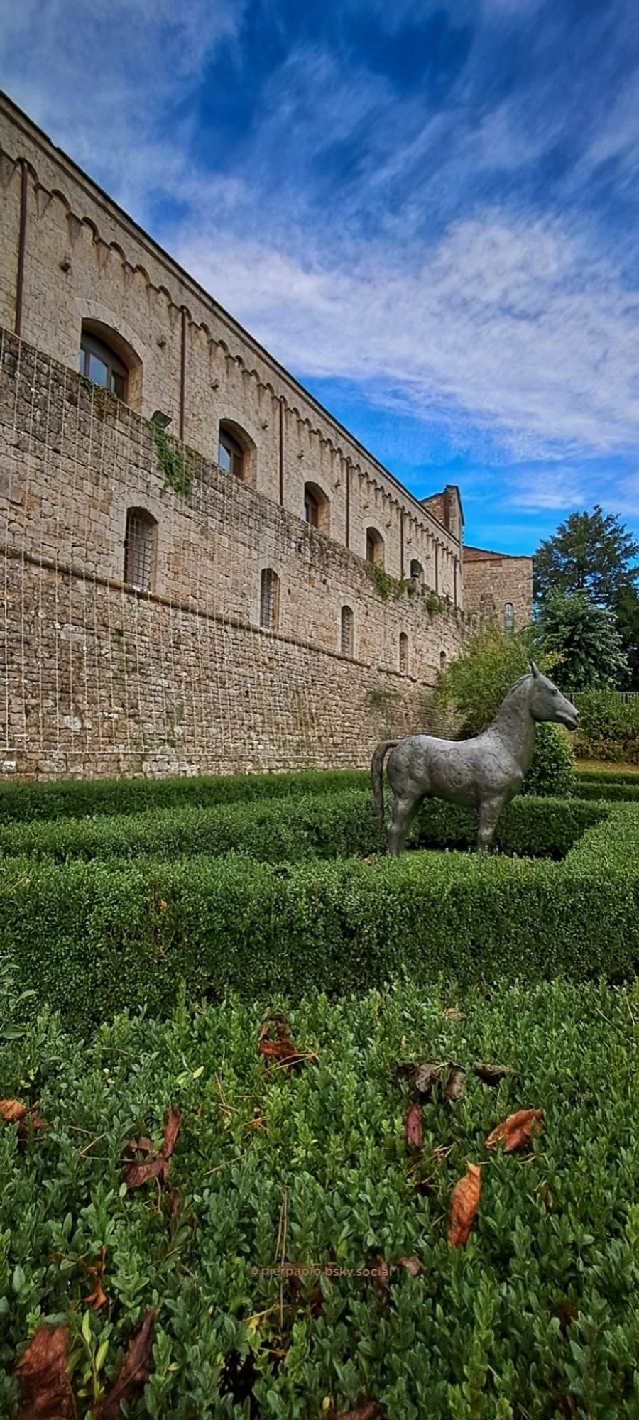 La Fortezza Medicea di Montepulciano. In mezzo al giardino all'italiana con siepi di bosso, è installata una scultura in bronzo che riproduce un cavallo.