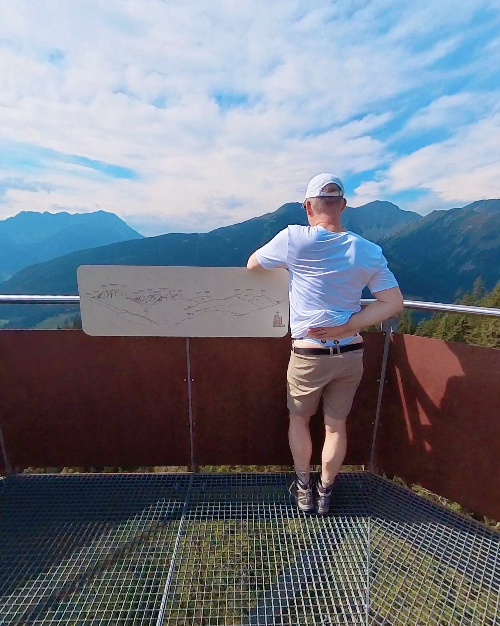 Standing on a viewing platform, facing away from the camera, flashing my thong underneath my clothes