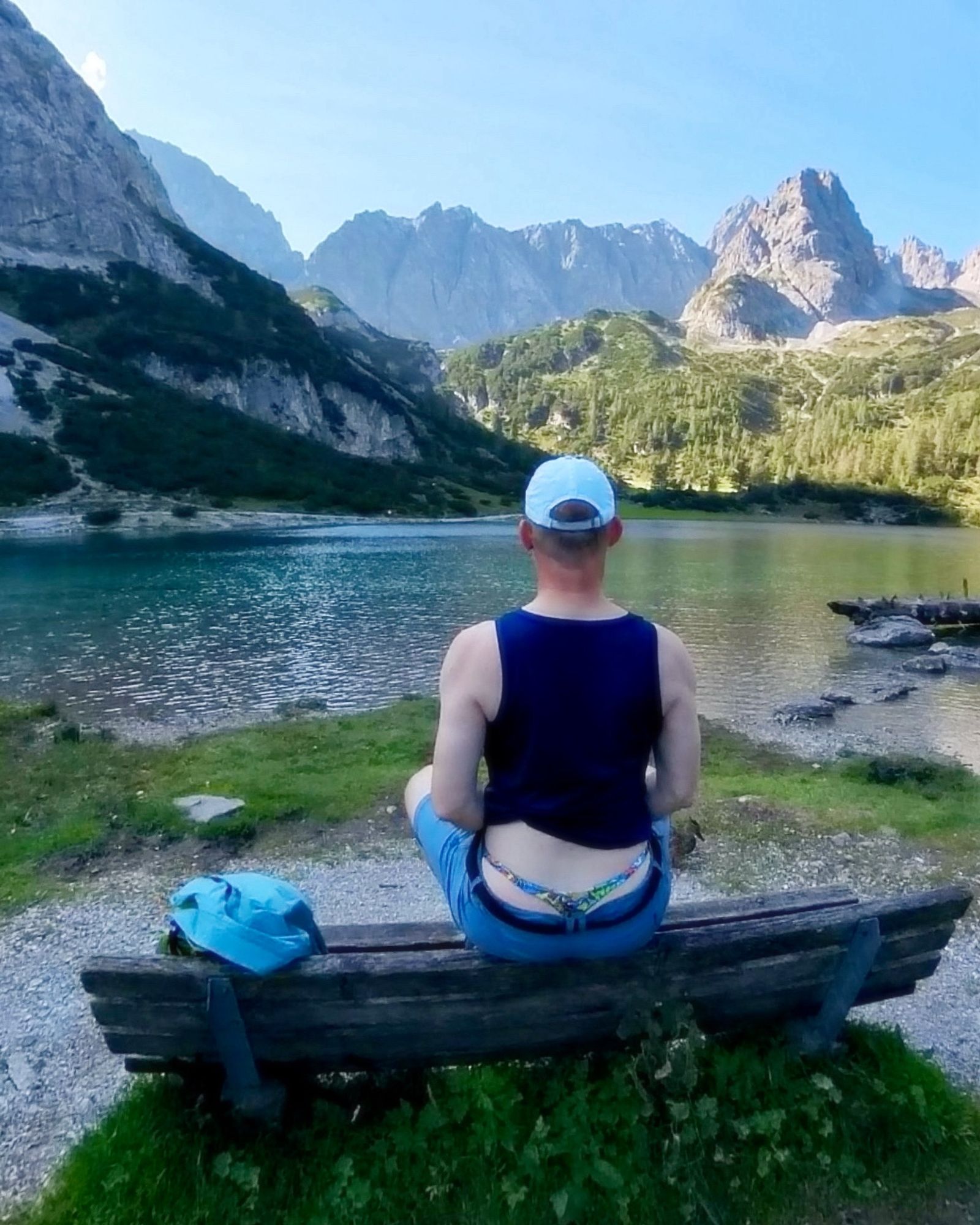 Sitting on the back of a bench at Seebensee, facing away from the camera flashing my thong underneath