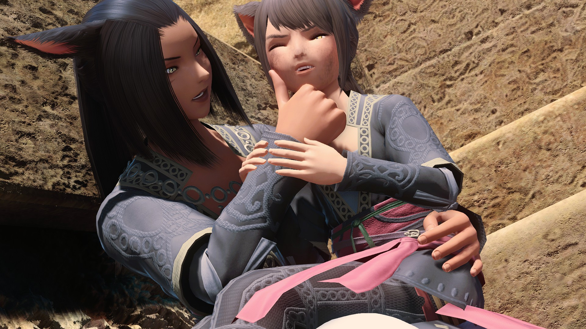 P'lanaa Koda holds her daughter Uuma on her lap, reaching out to wipe one of several dirt smears from her daughter's cheek, despite Uuma's fruitless attempts at resisting her mother's care.