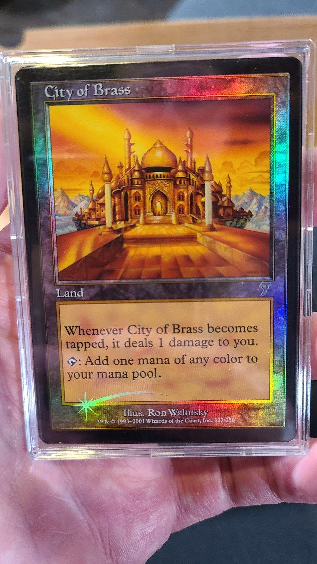 A foil 7th edition City of Brass card in an acrylic snap case