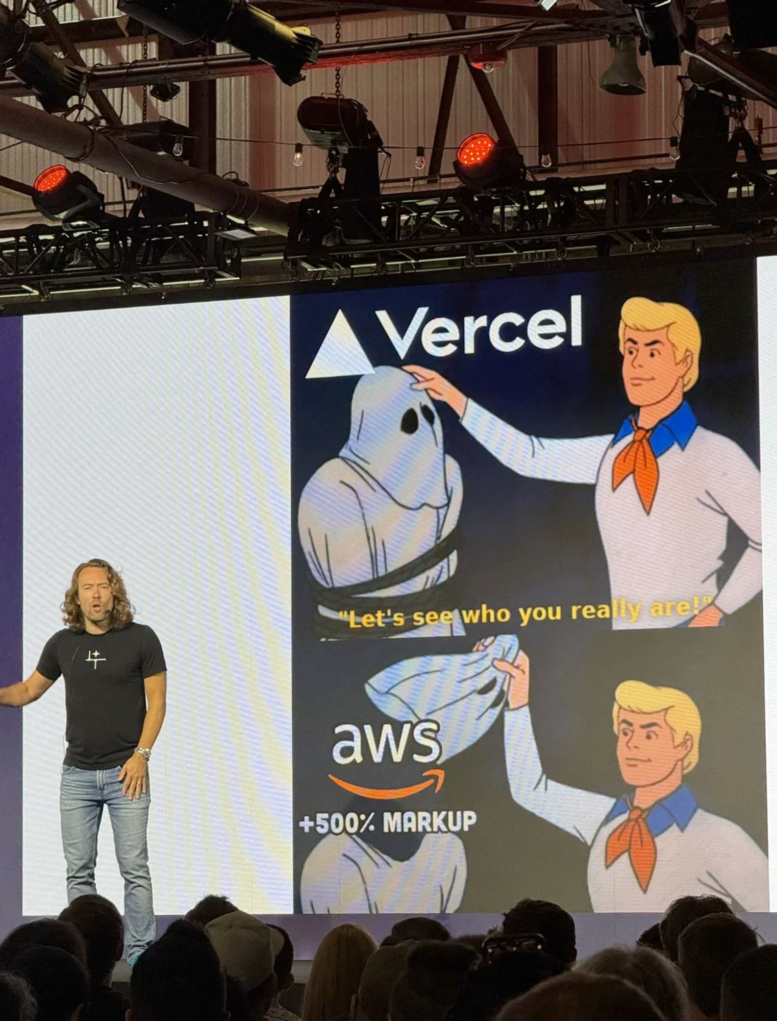 DHH presenting a meme slide that has Freddy from Scooby Doo unmasking a ghost named Vercel and revealing that it is AWS with a 500% markup.