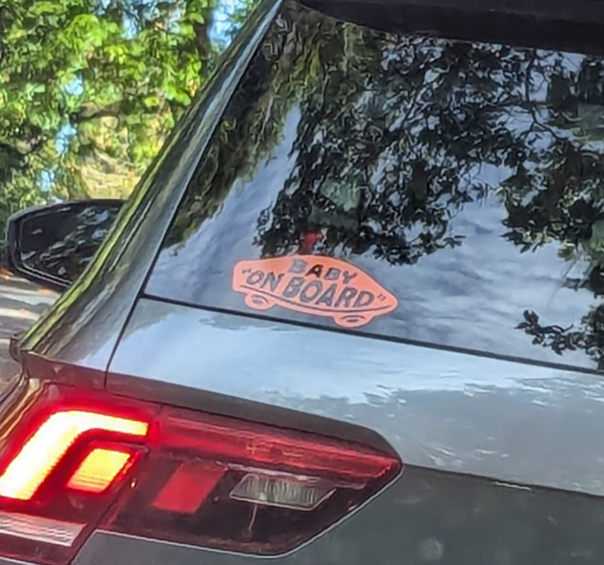 A sticker in the Vans logo style that reads, "baby on board'