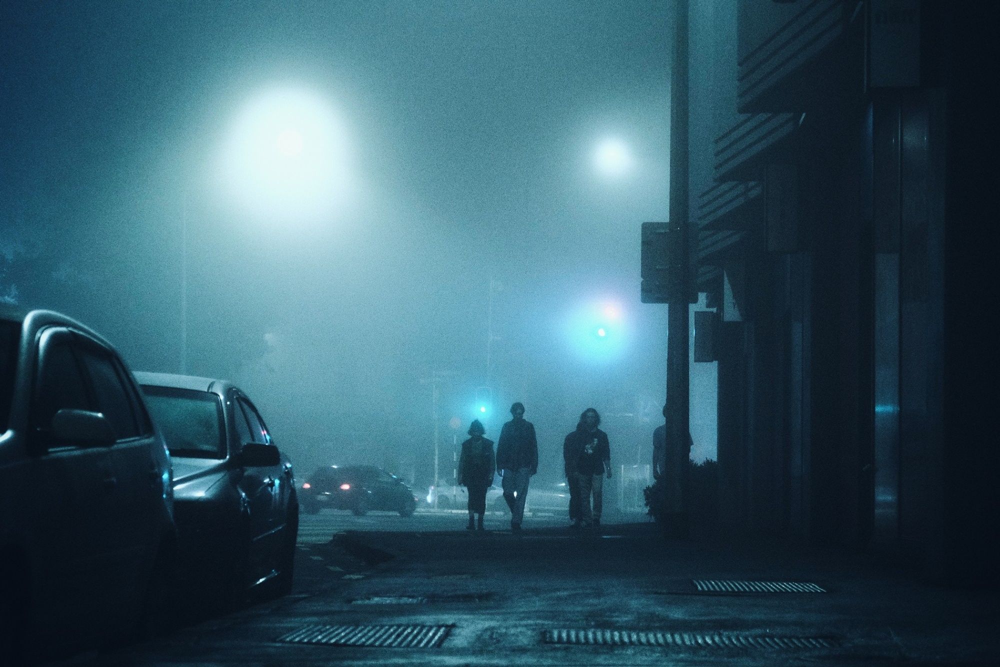 Hazy street photography with a bunch of people is walking to the camera for the fog. Blue hour vibe 