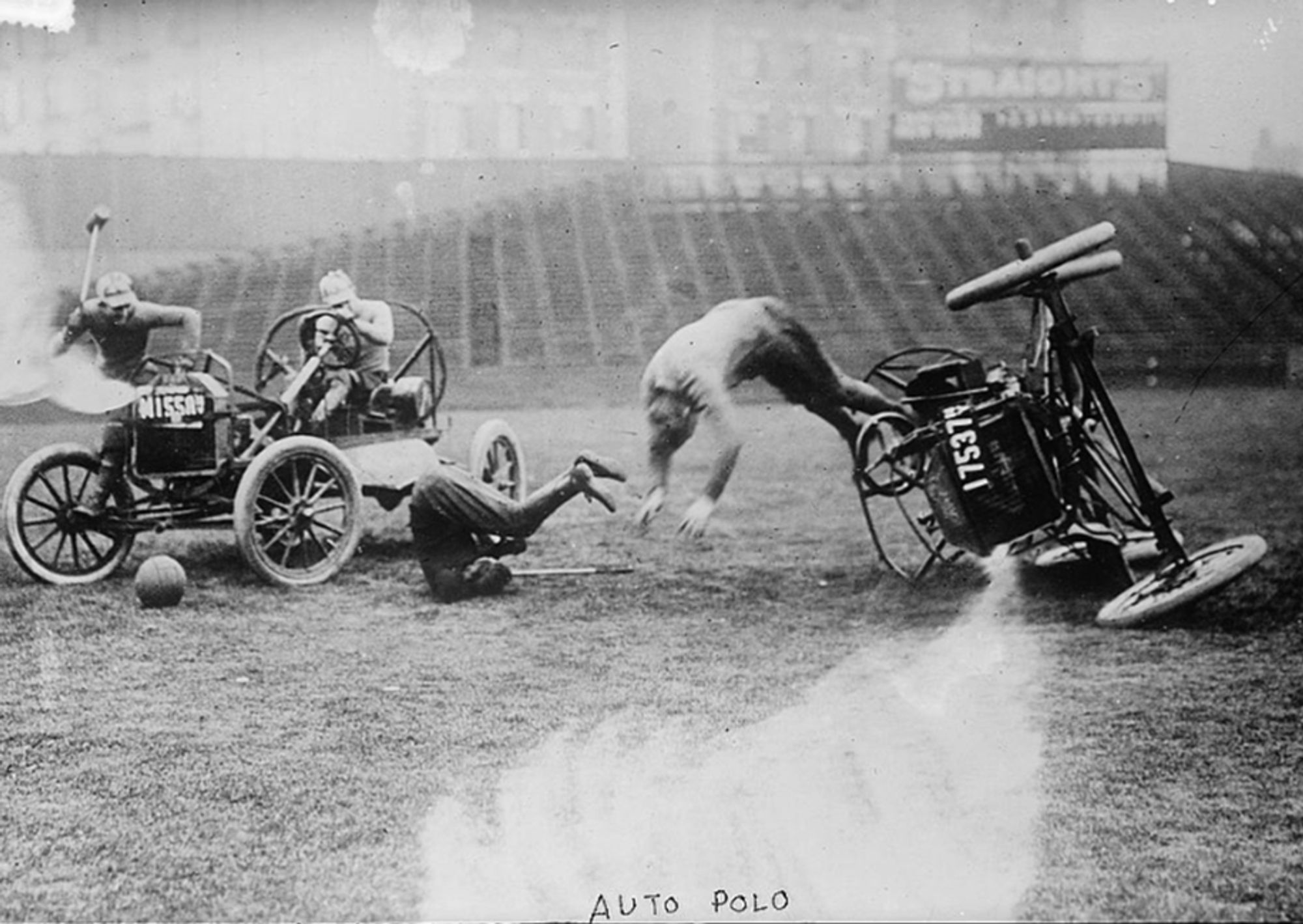 Black and white photo labeled "auto polo" depicting two early 1900's automobiles in a football stadium during a crash with one driver tumbling from the car and a ball sitting near the other car.