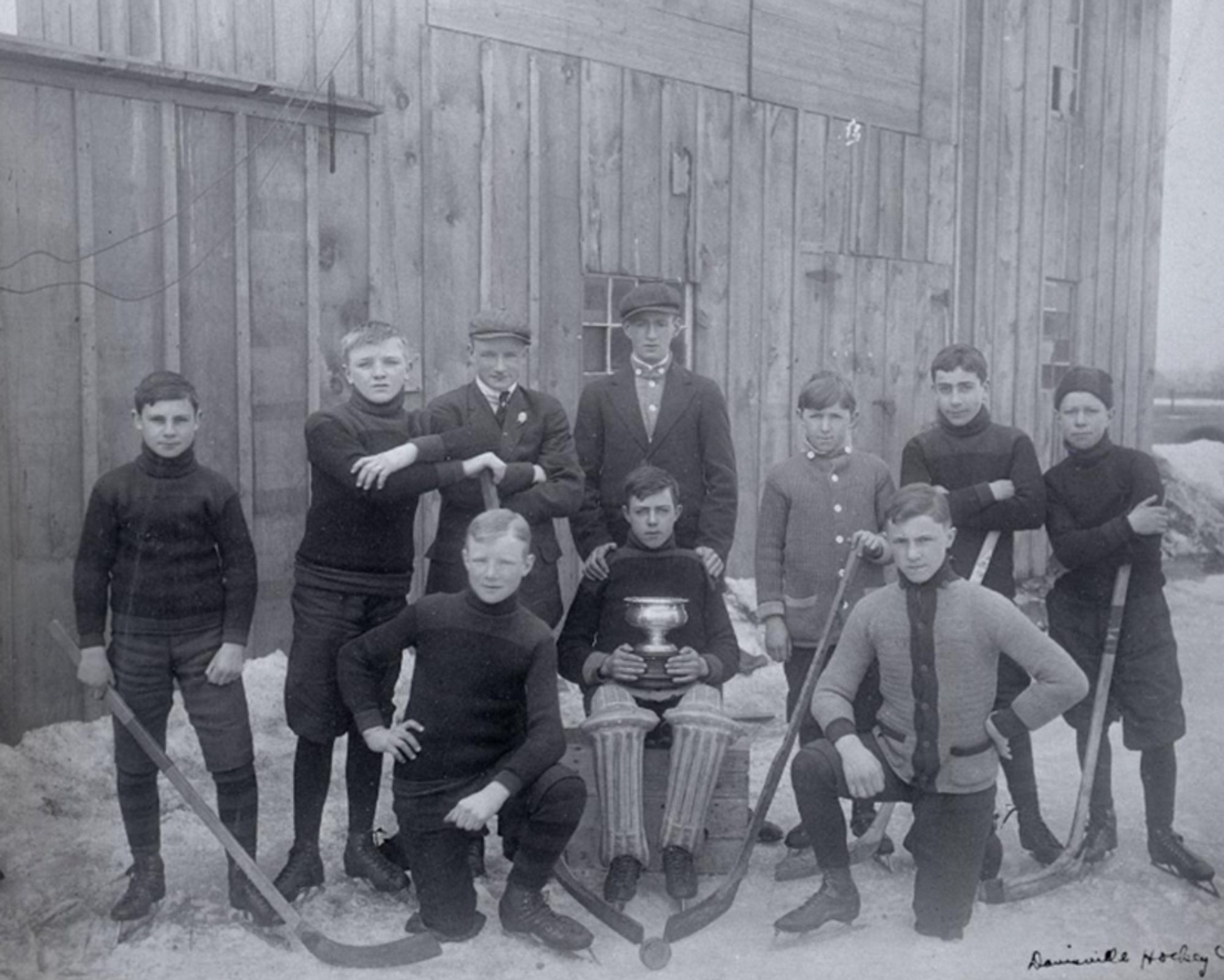 Black and white image of boys hockey team posing outside with a trophy. 1911-12. From the Toronto Public Library Archive