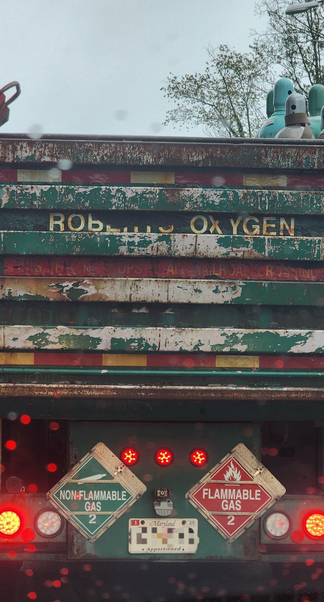 The back of a green oxygen tank transportation truck. It is beat to shit, but the weathering looks very cool.