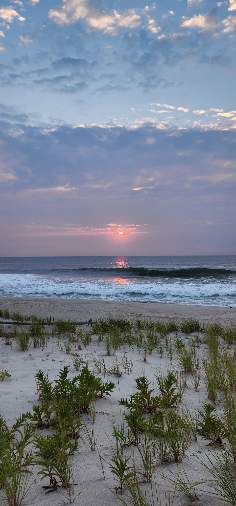 A picture of the sun rising over the ocean.