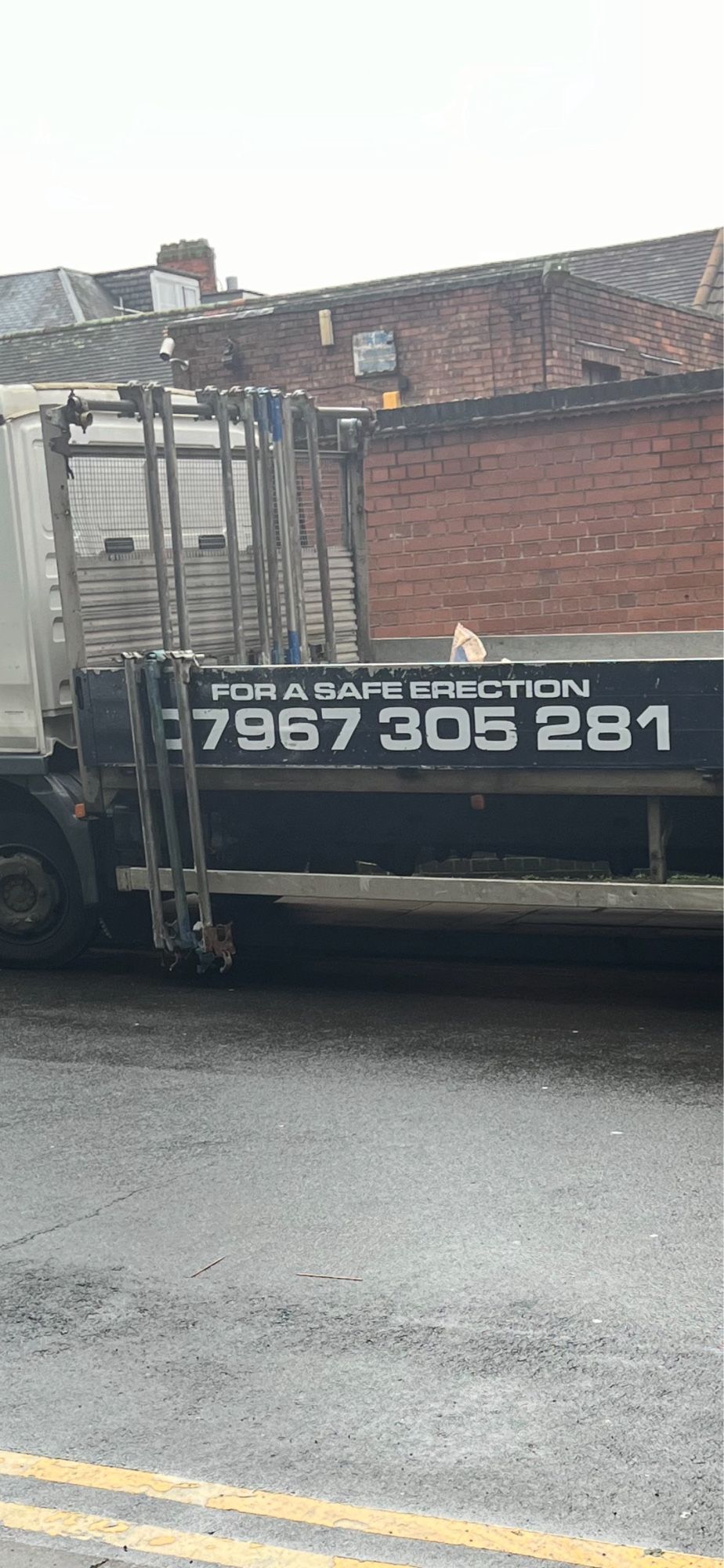 A truck that carries scaffolding equipment. It reads, “For a safe erection”.