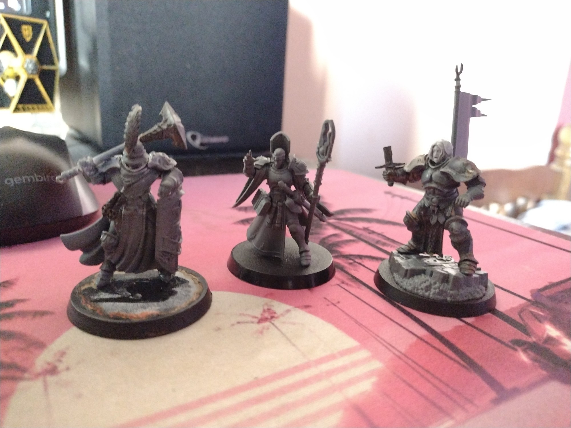 Unpainted Stormcasts, one guy with a sword and banner, one with shield and hammer and a wizard