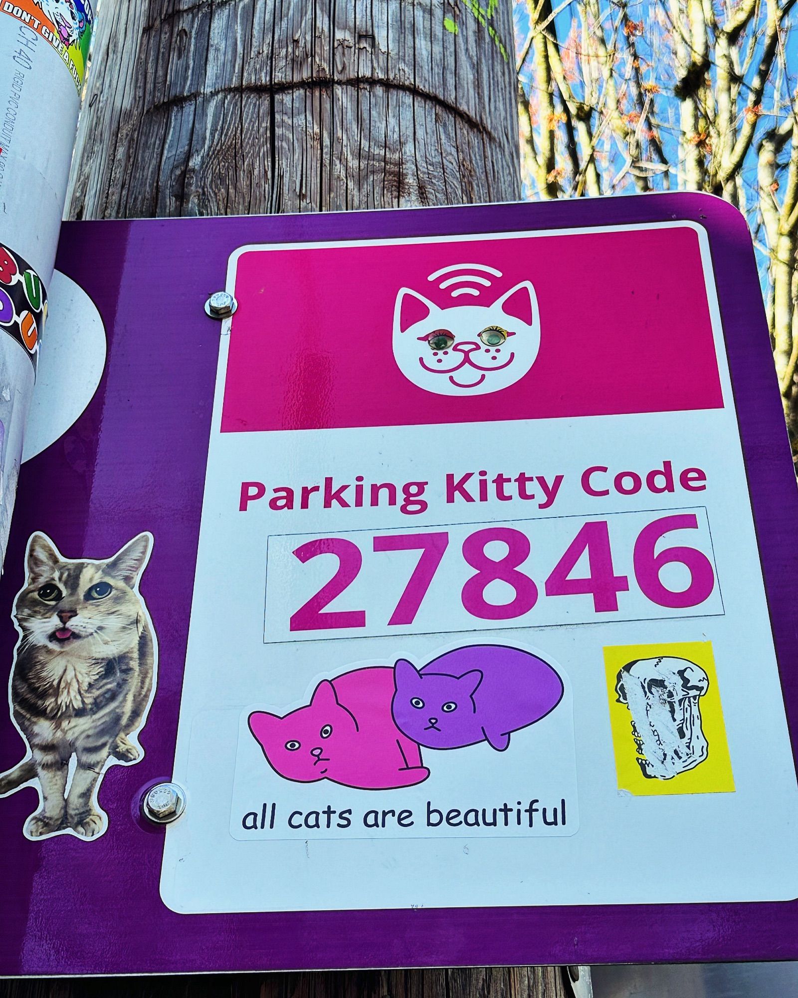 A few stickers adorn a street parking sign